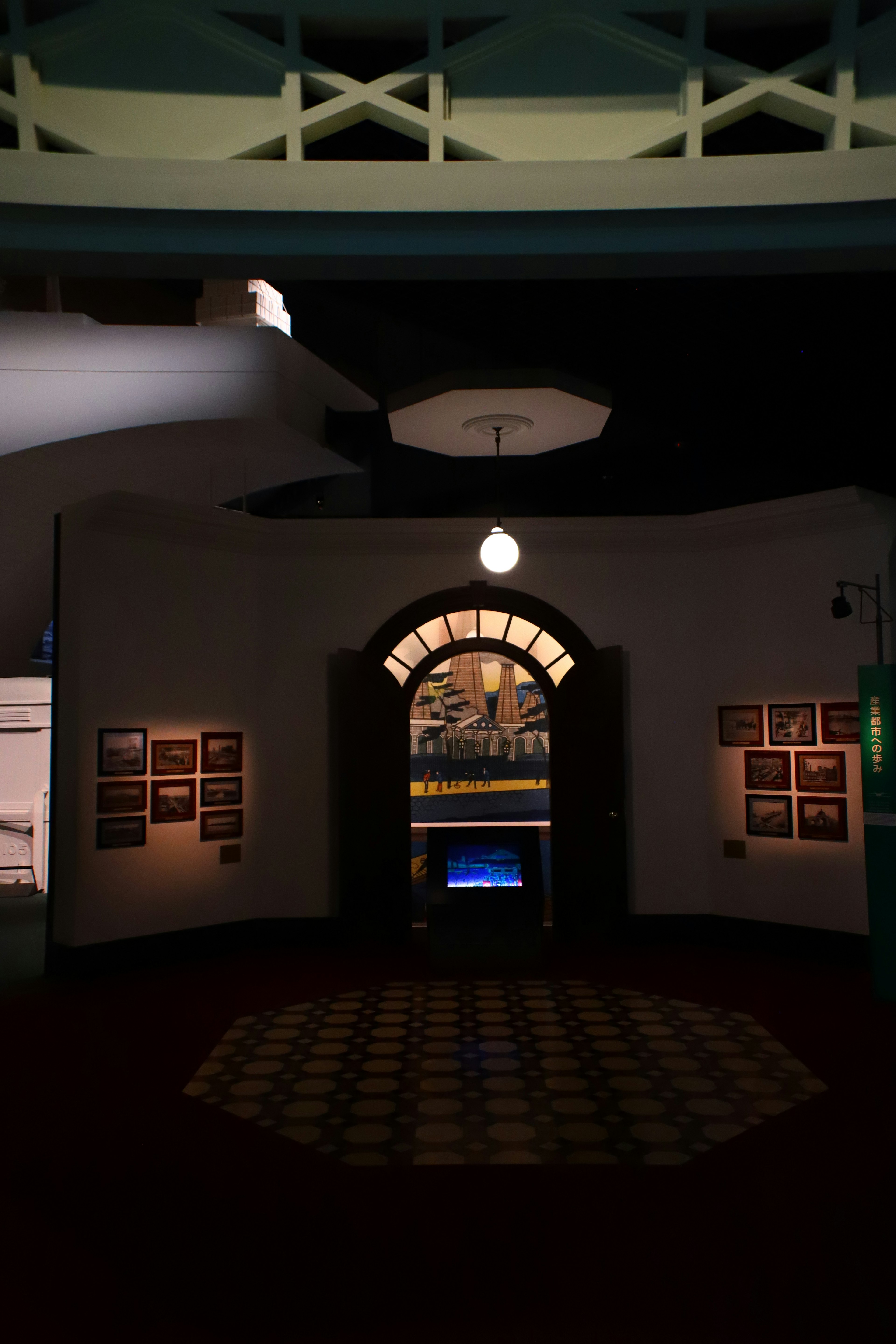 A dimly lit interior featuring an elegant archway door with displayed photographs around