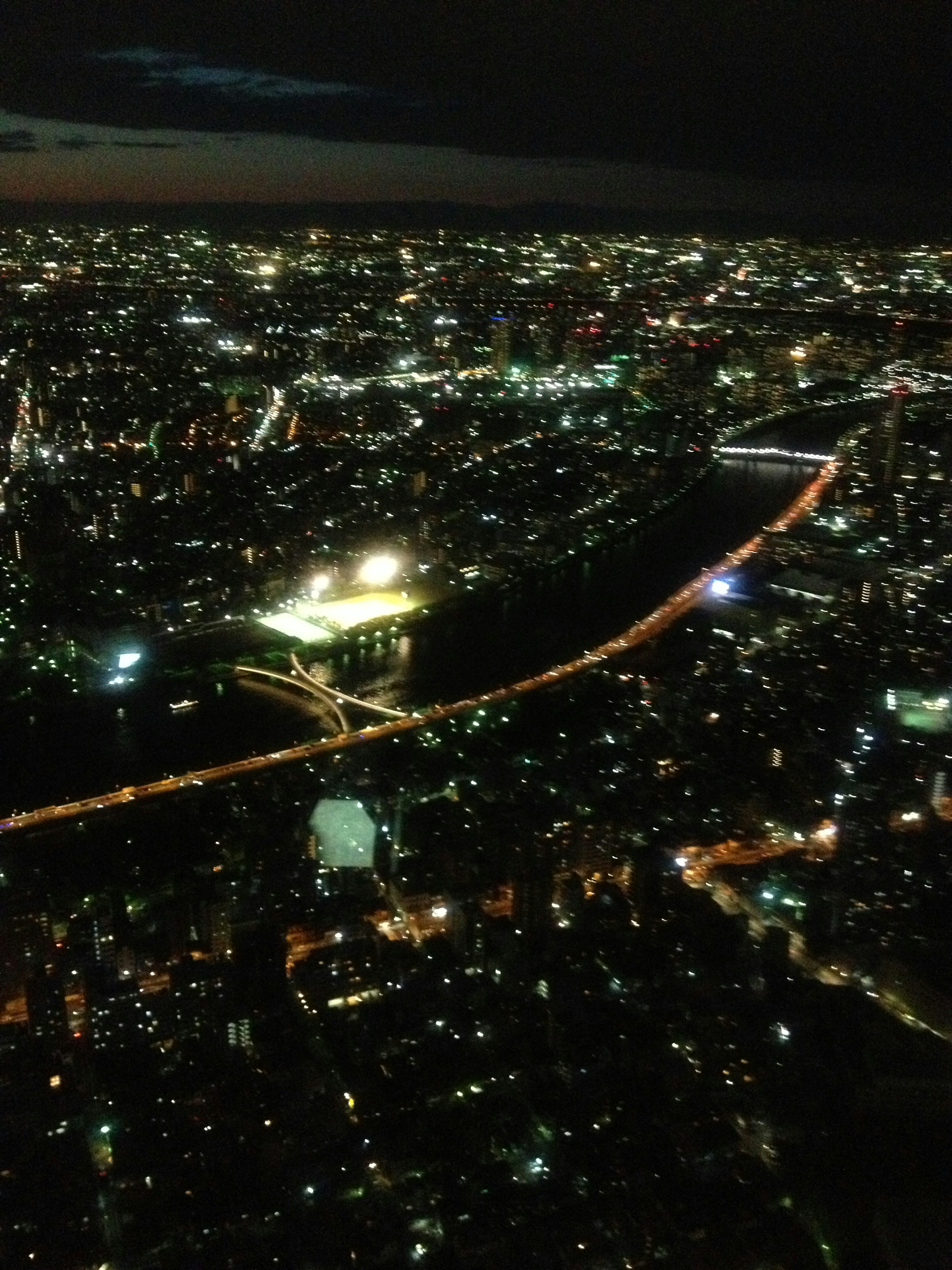 Vue nocturne de la ville avec des bâtiments illuminés et une rivière sinueuse