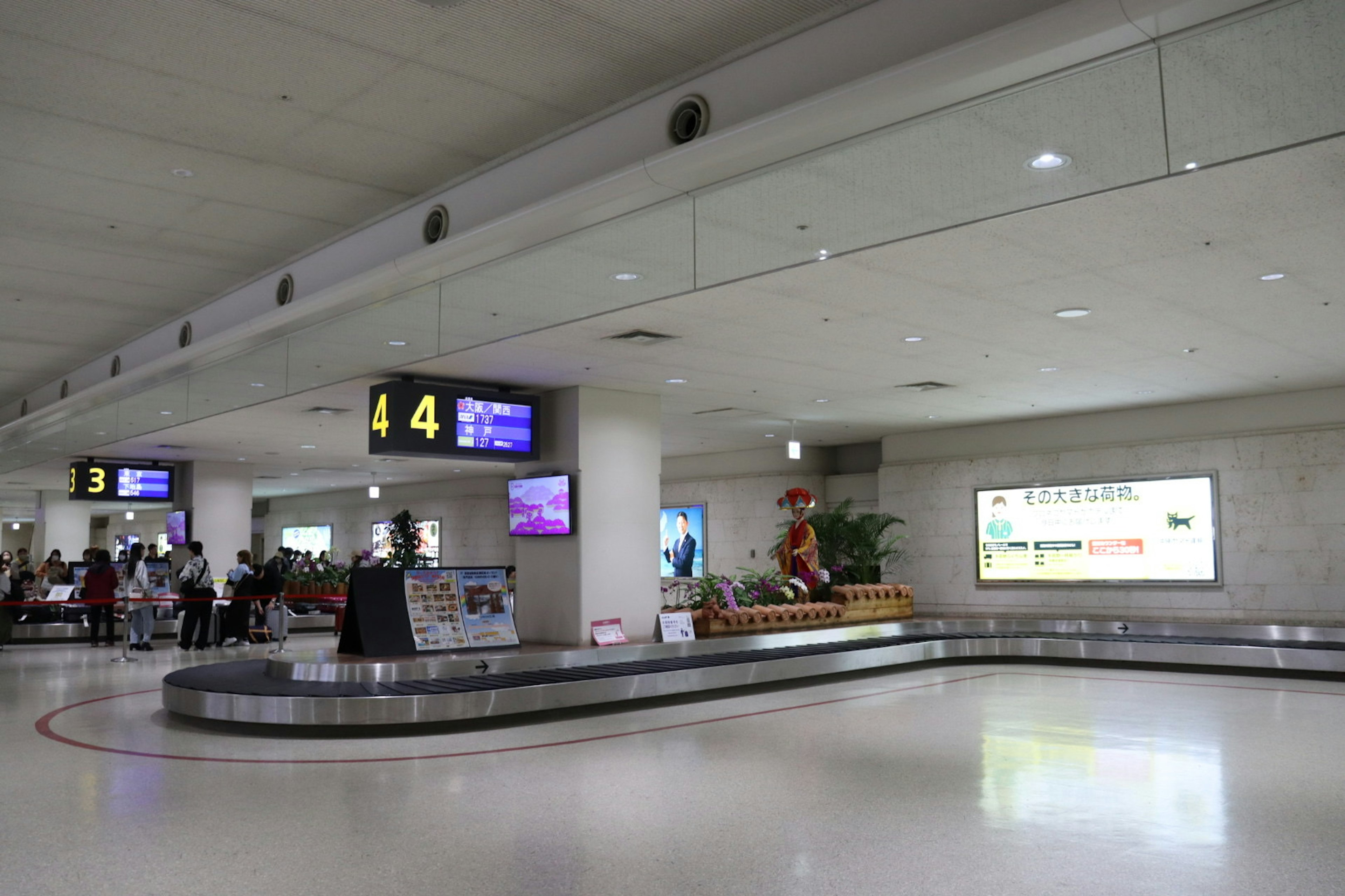 Zone de récupération des bagages d'aéroport avec des panneaux d'arrivée et un carrousel à bagages