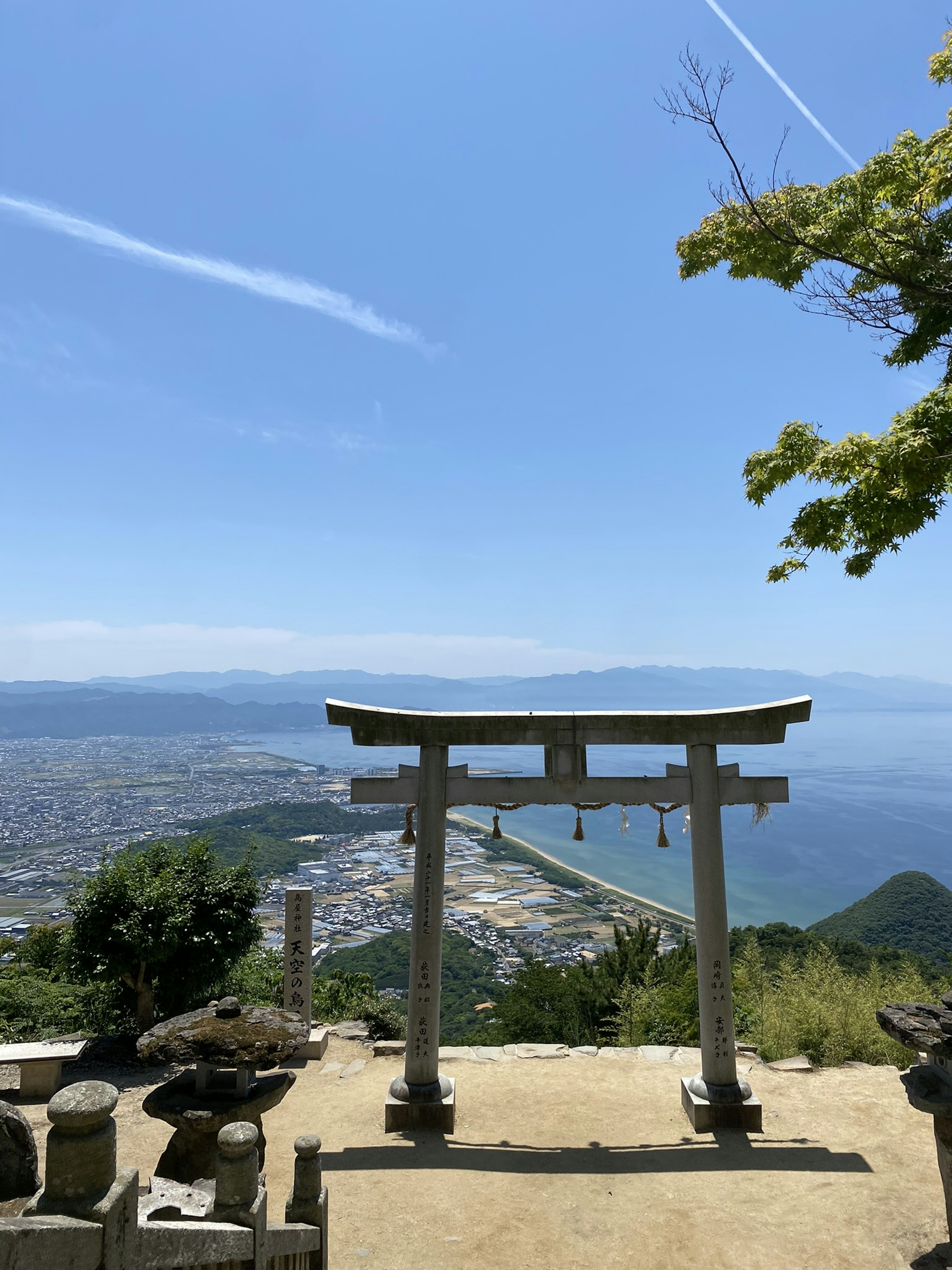 Porta torii sotto un cielo blu con un paesaggio mozzafiato