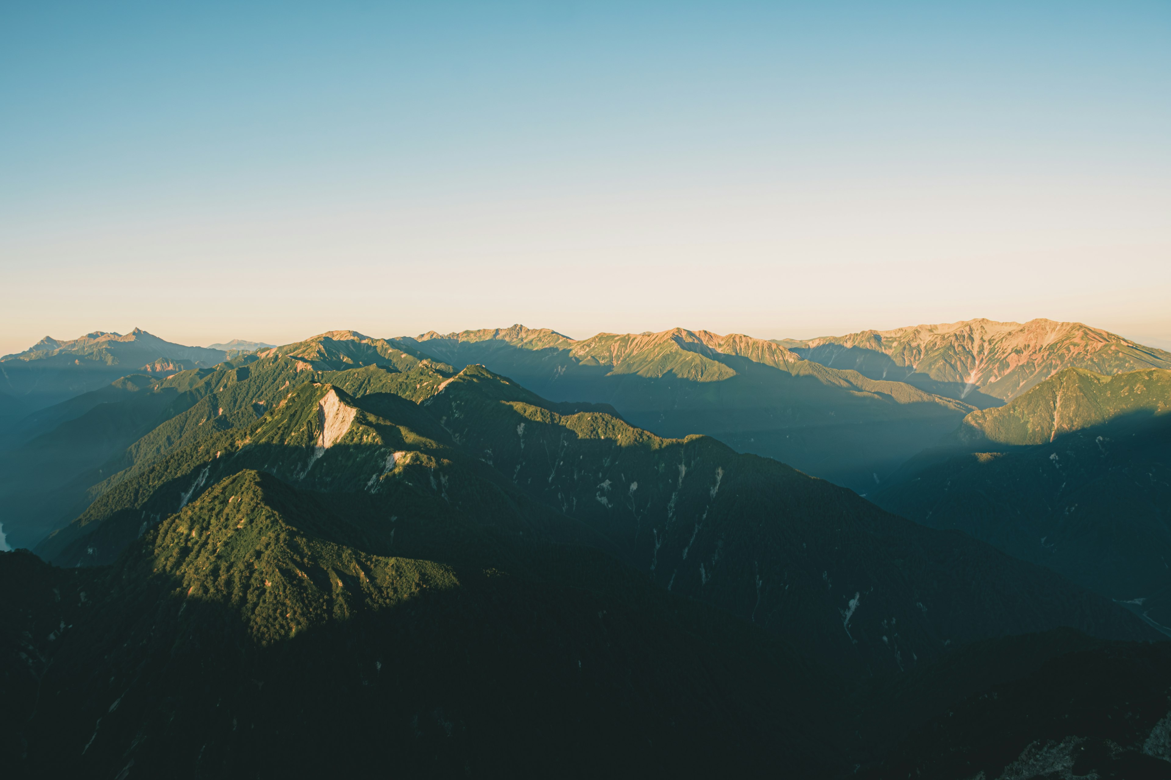 青空の下に広がる山々の壮大な景色と影