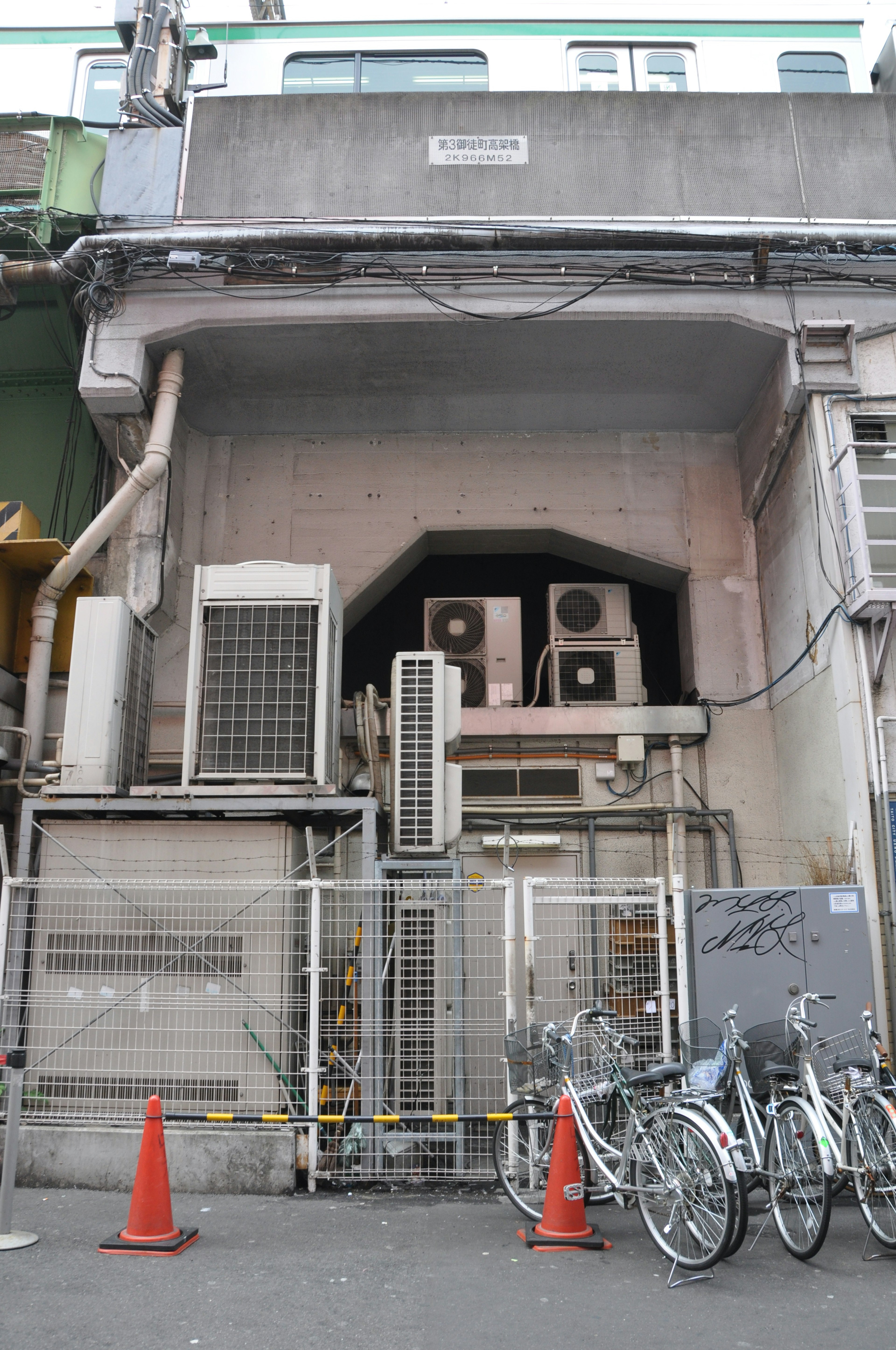 Back of a building featuring air conditioning units and parked bicycles