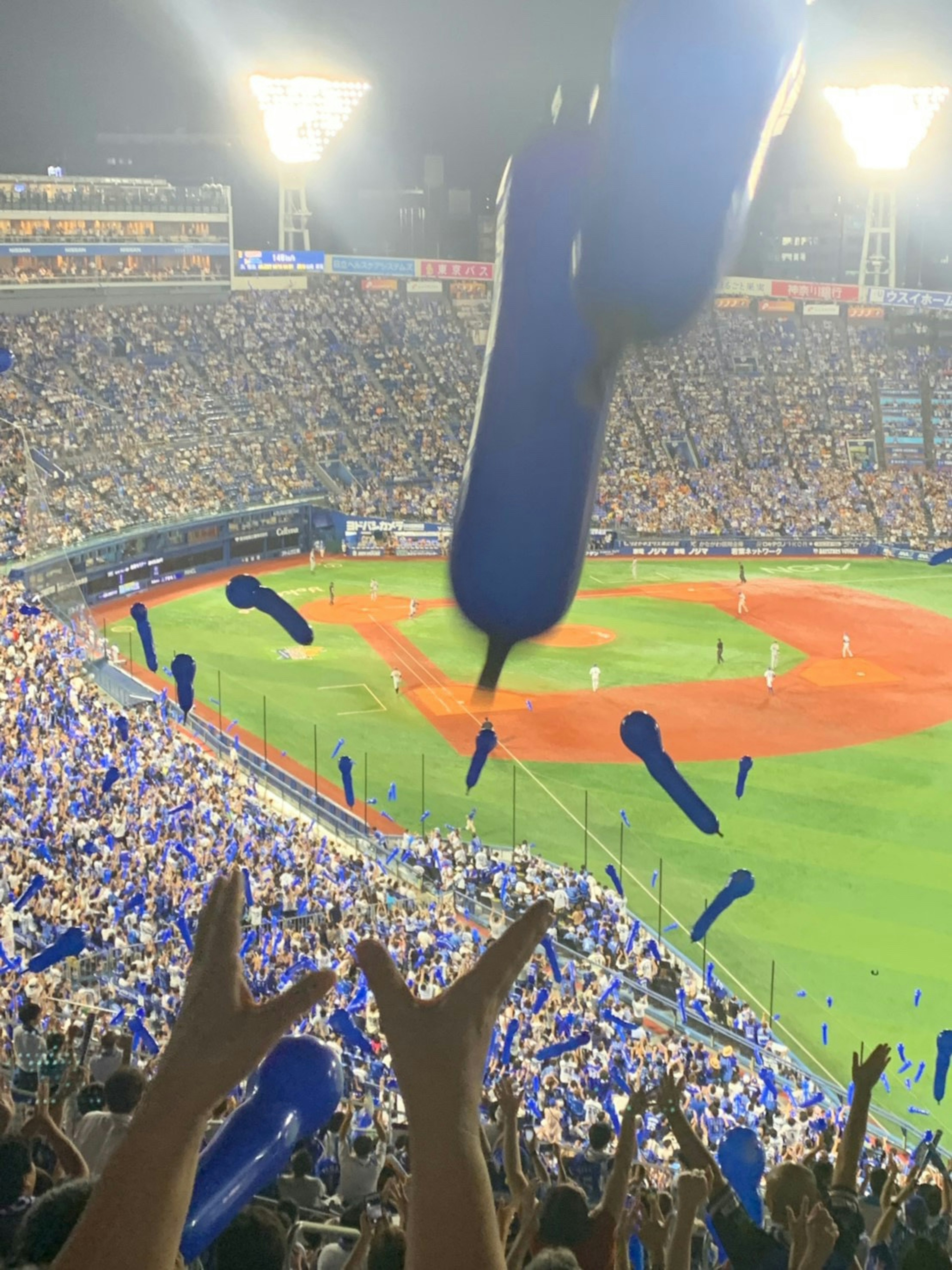 Fans waving blue cheering items in a baseball stadium