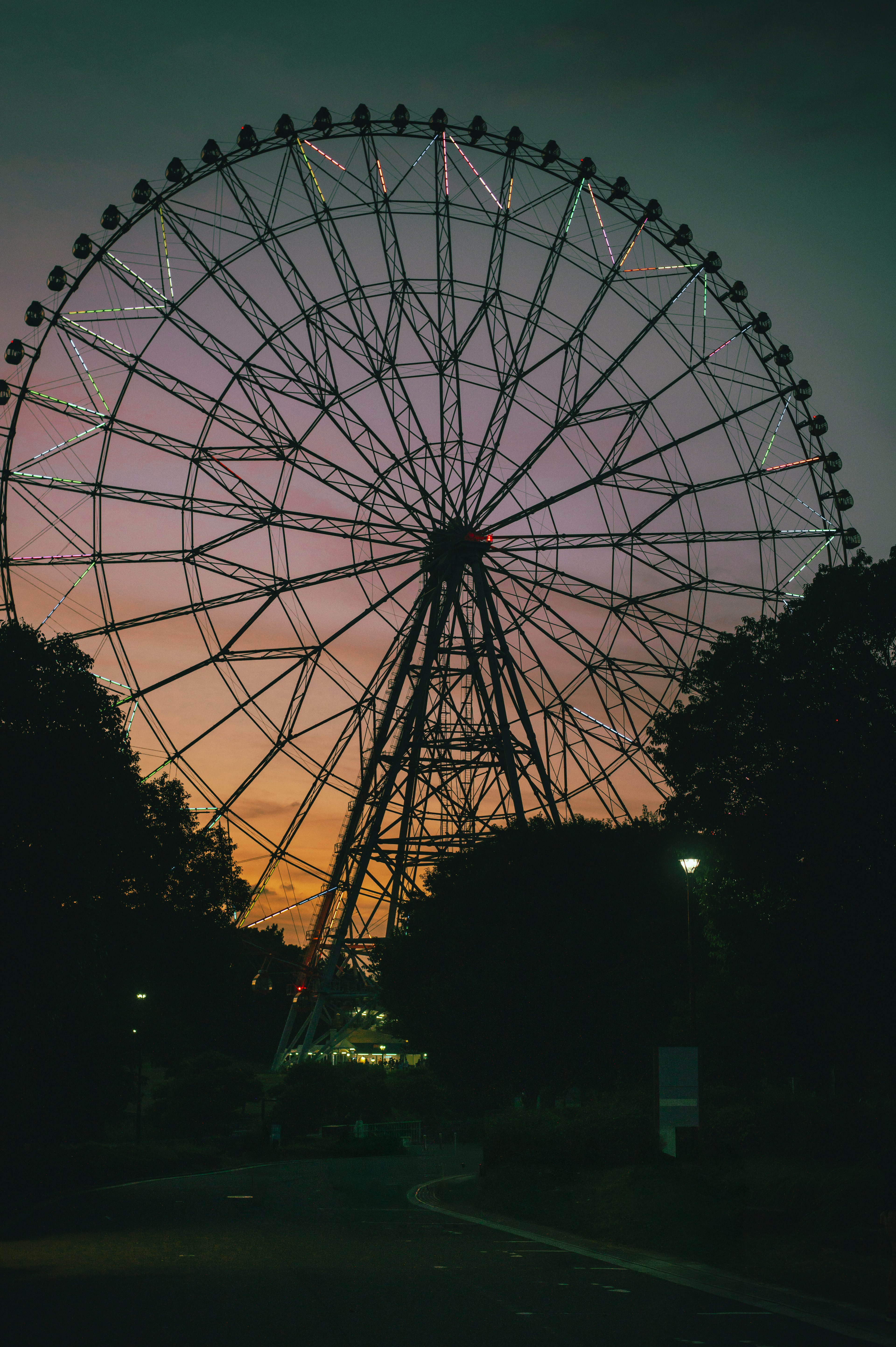 Silhouette of a ferris wheel against a sunset sky