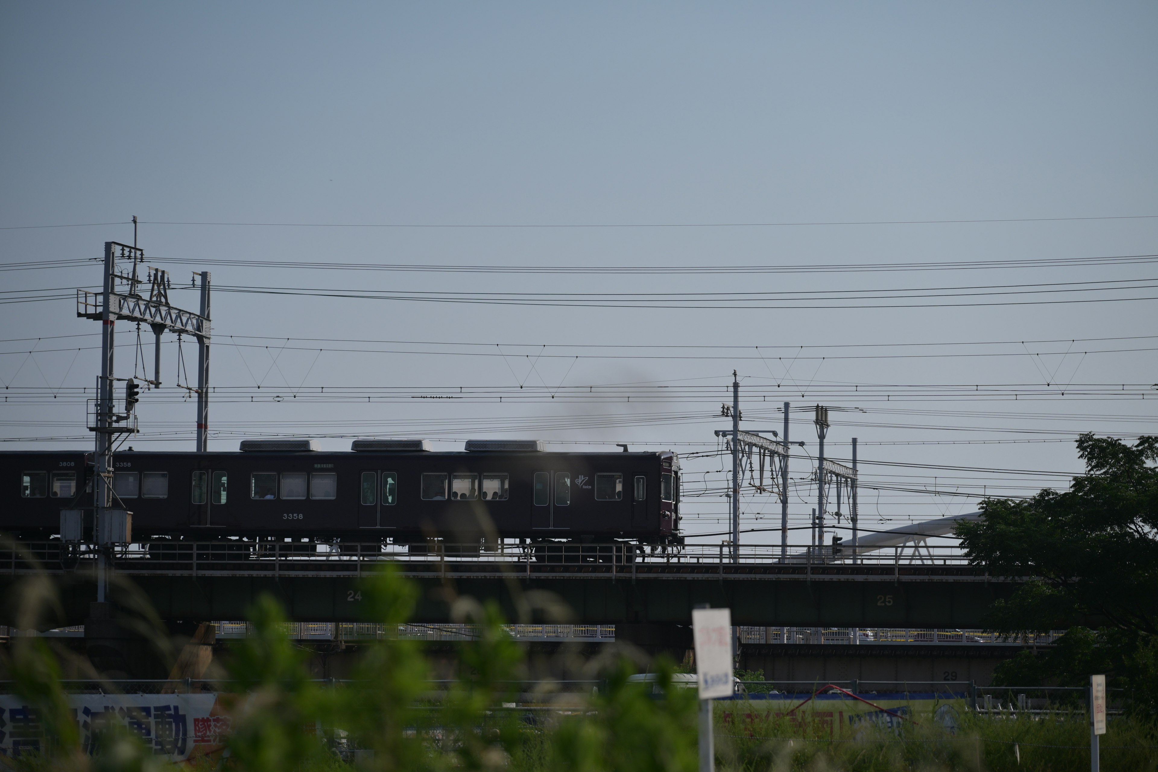 A train traveling on elevated tracks with power lines in the background