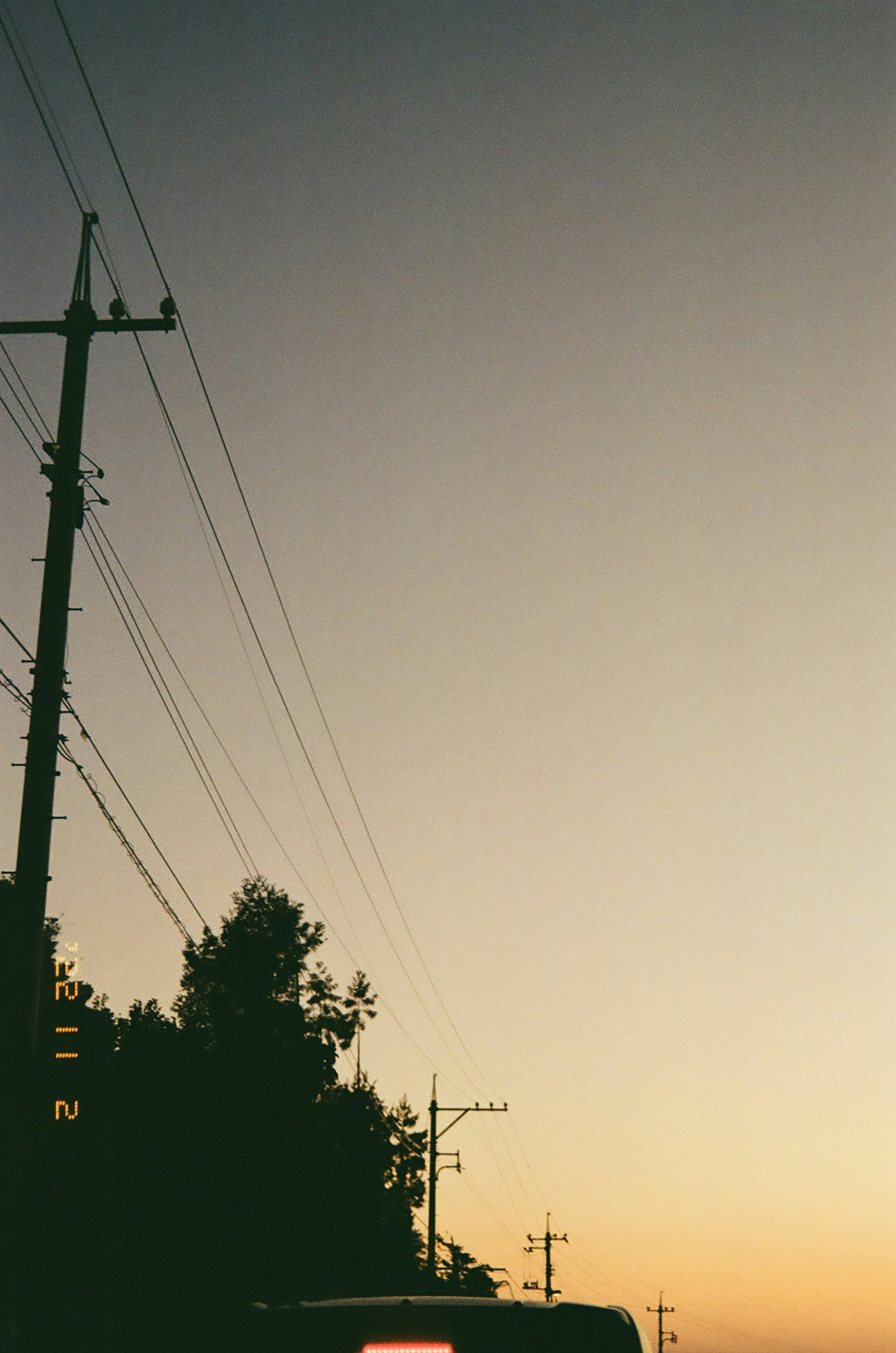 Silhouette of power lines against a sunset sky