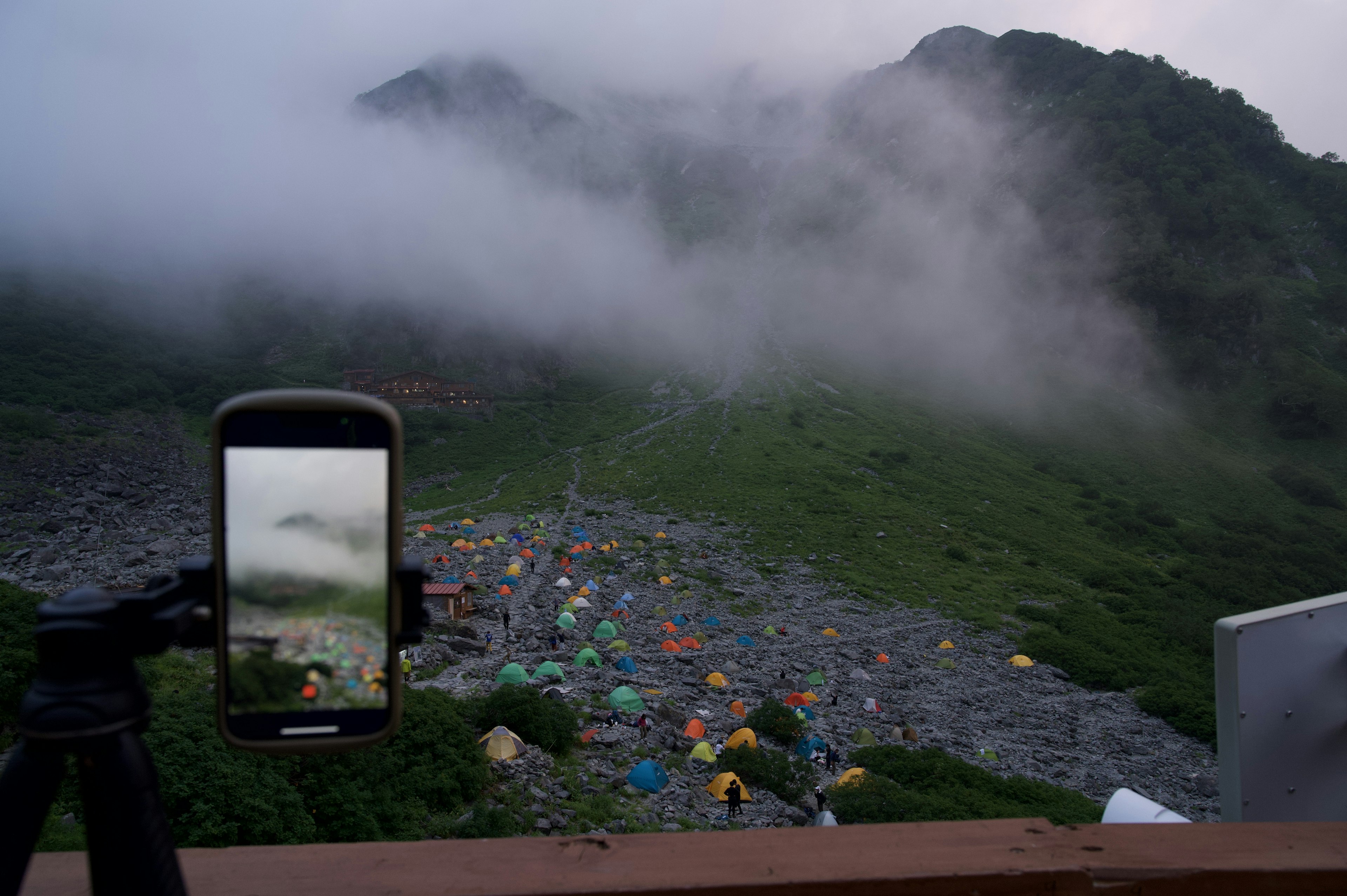 Mountain landscape with a fog-covered campsite captured on a smartphone