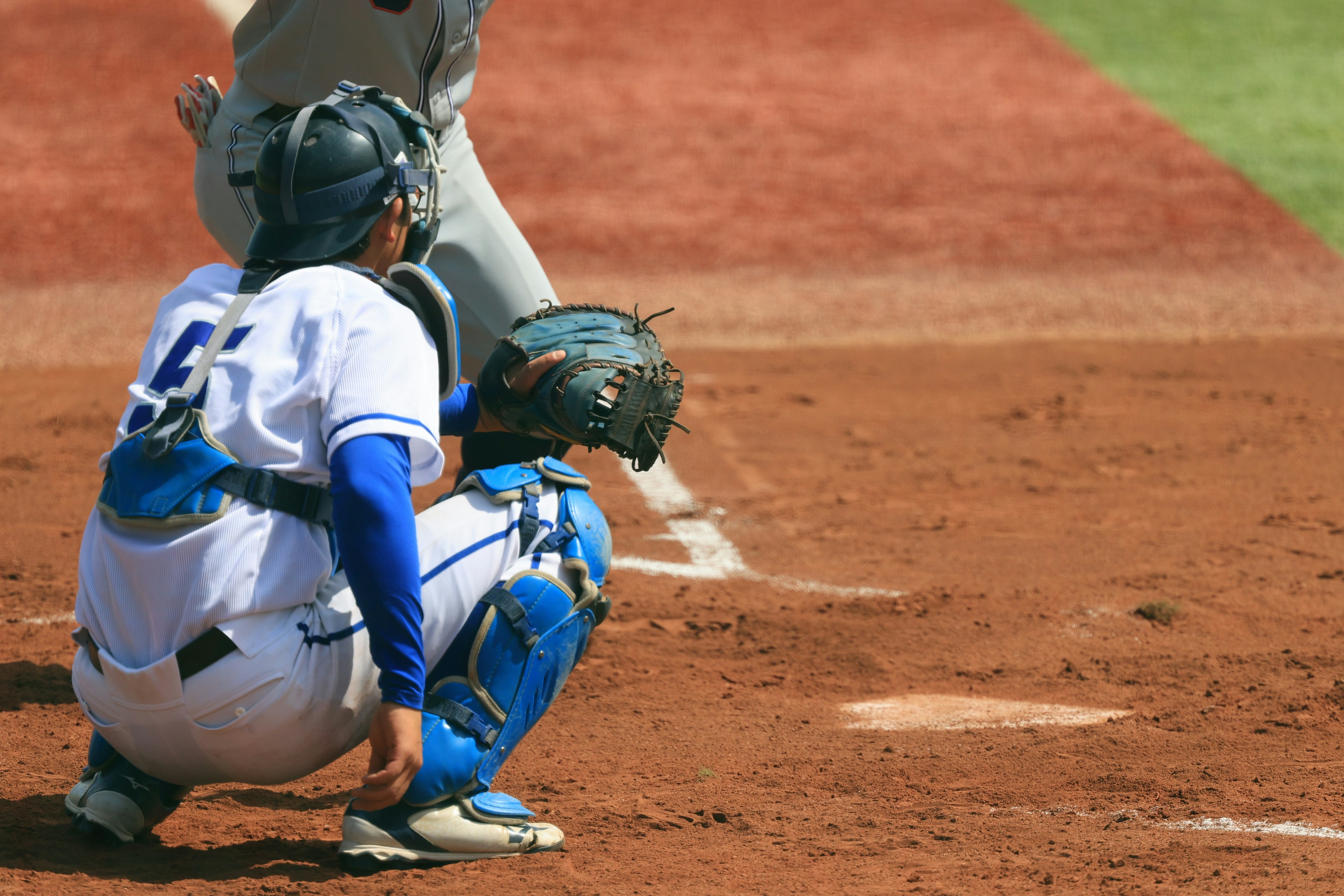 Baseball catcher crouching on the field