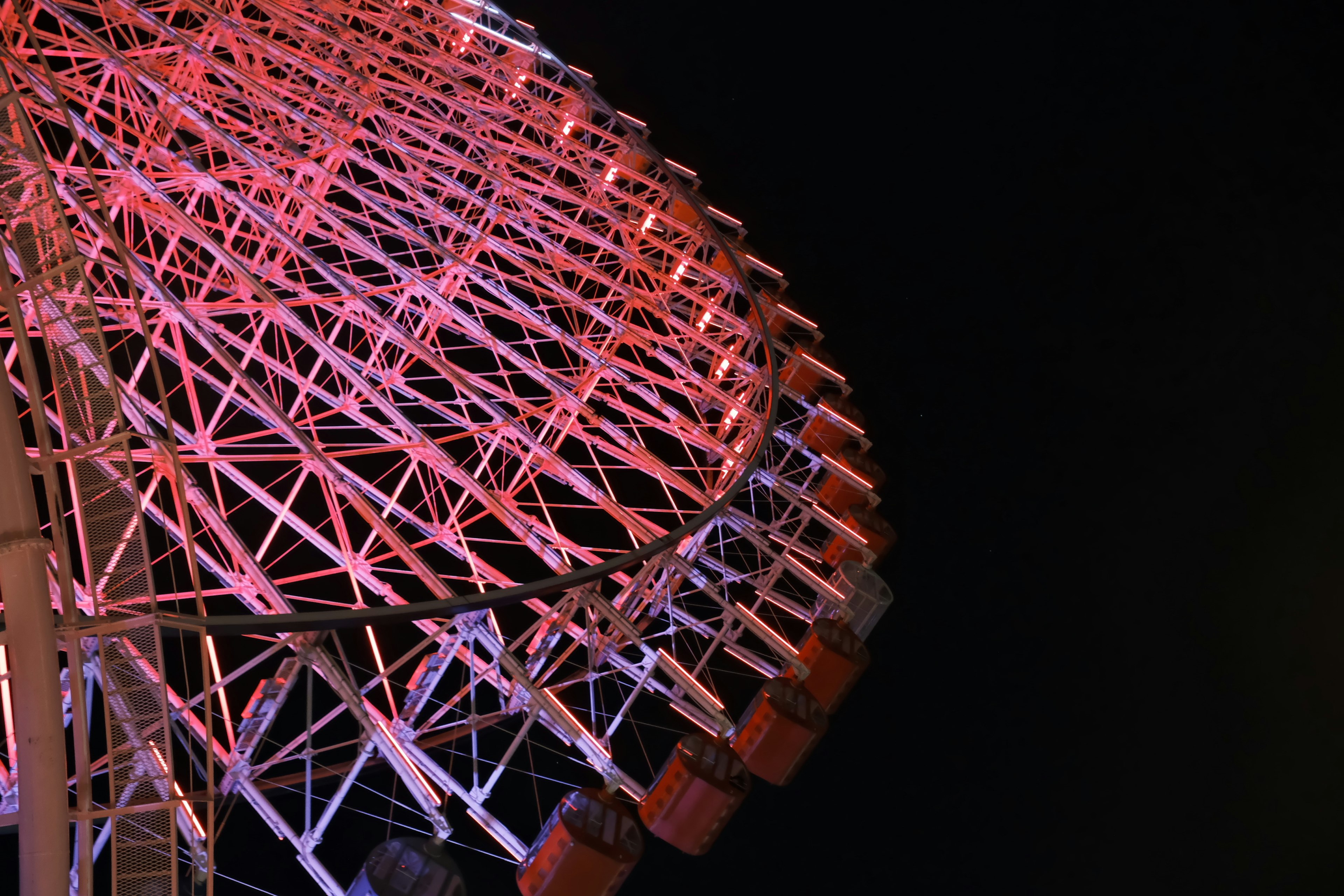 Colorful lights of a Ferris wheel against the night sky