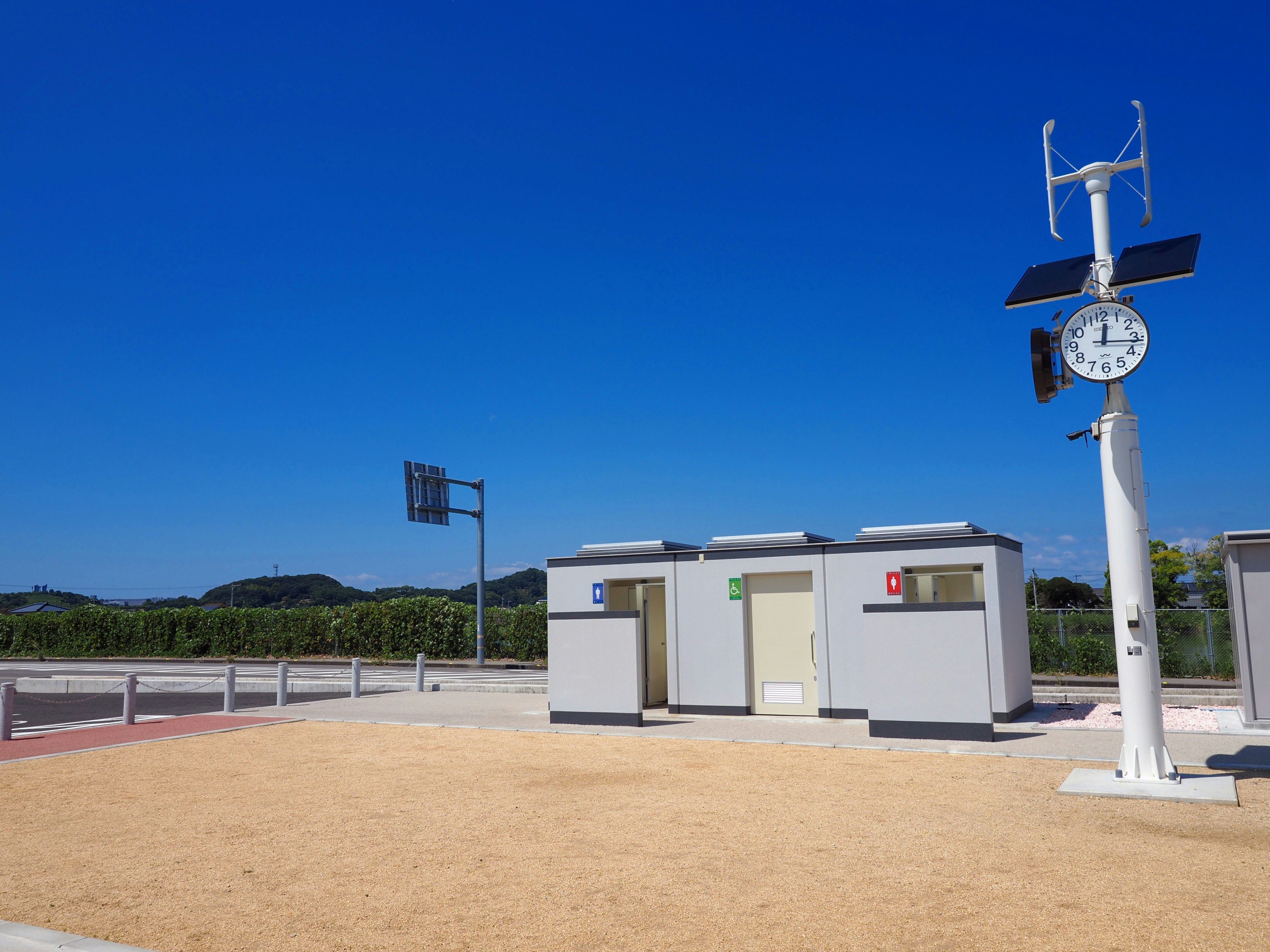 Toilettes publiques et horloge sous un ciel bleu clair