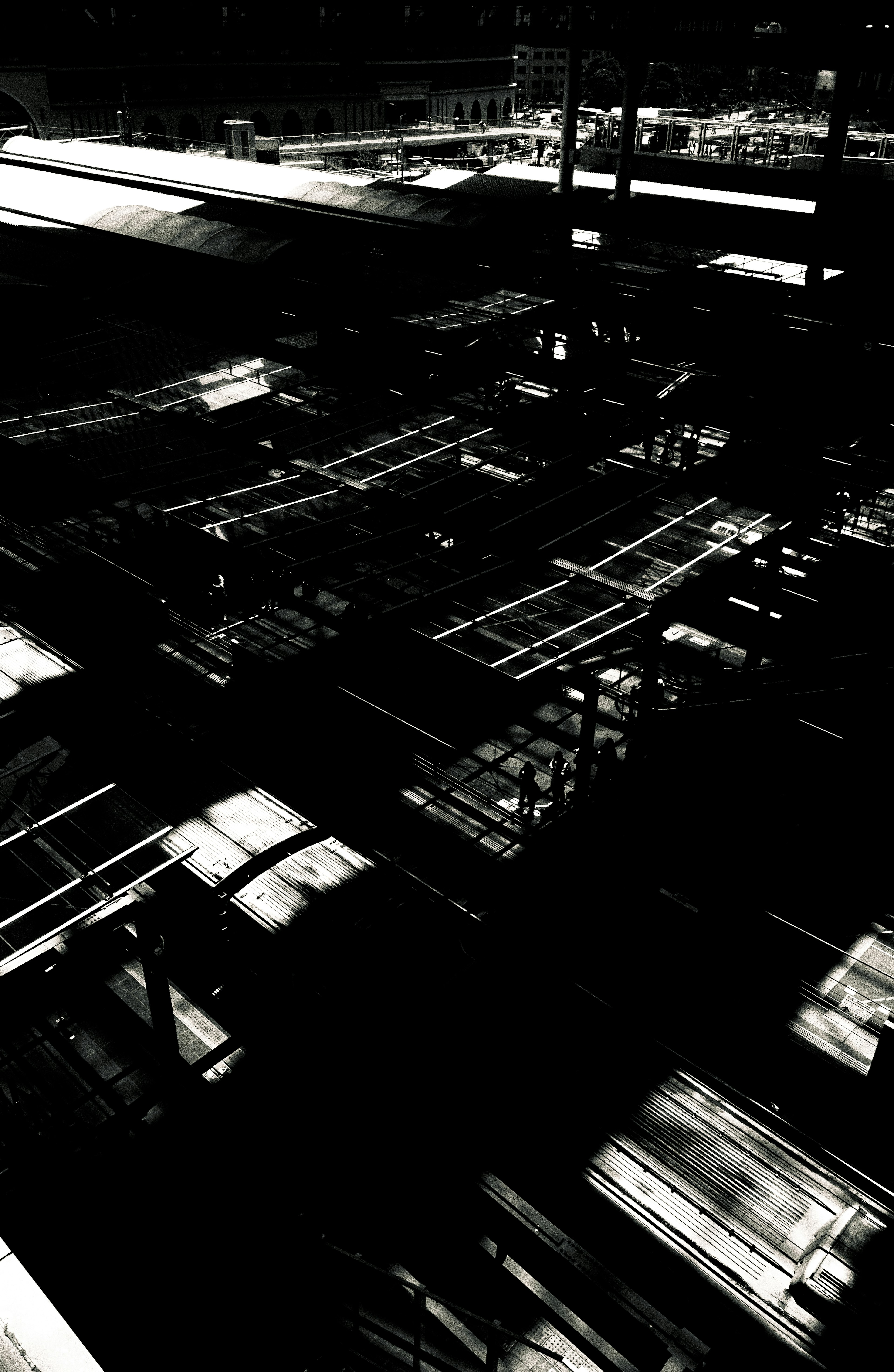 Image en noir et blanc à fort contraste des structures industrielles avec des ombres