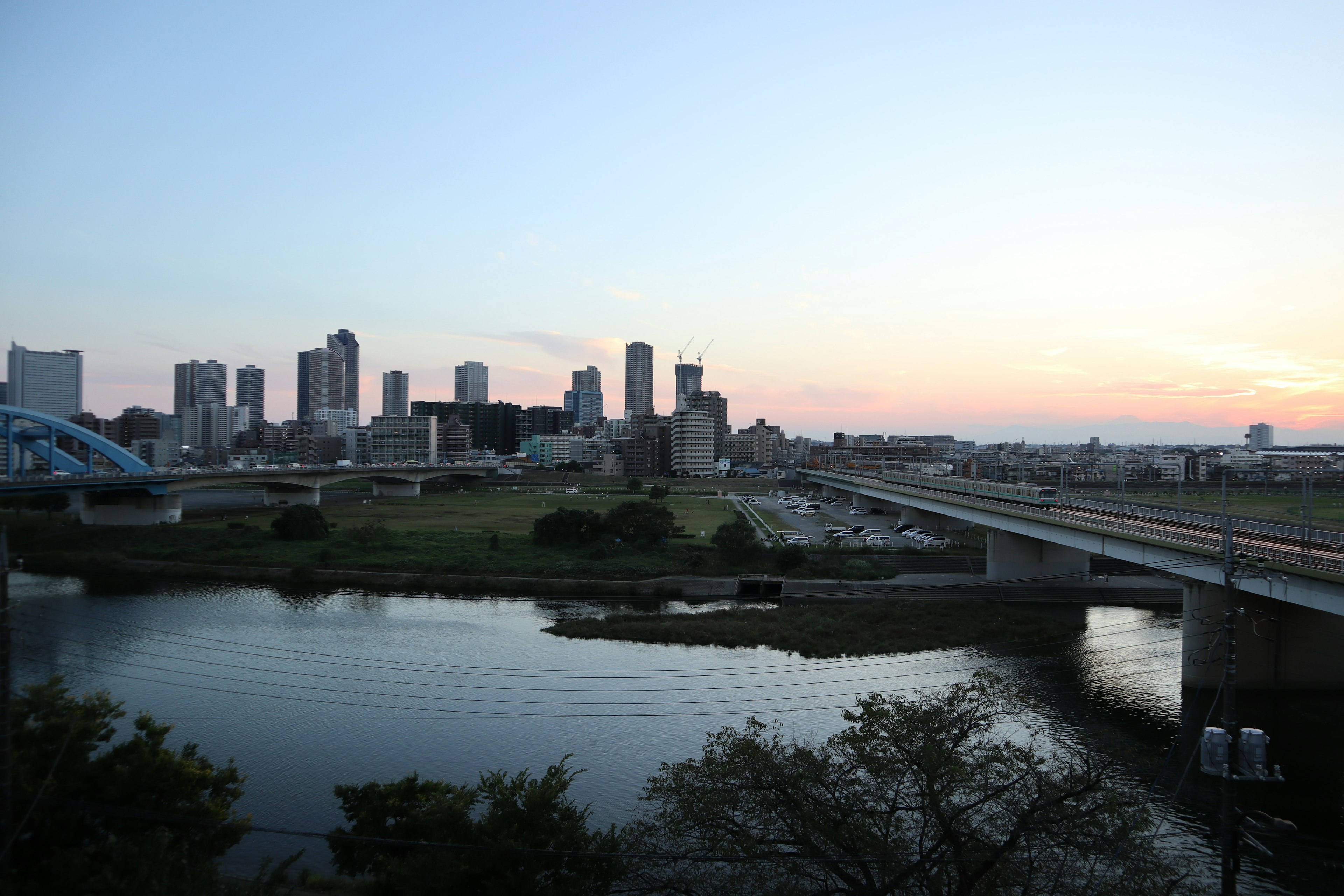 Skyline cittadina al crepuscolo con fiume e ponte