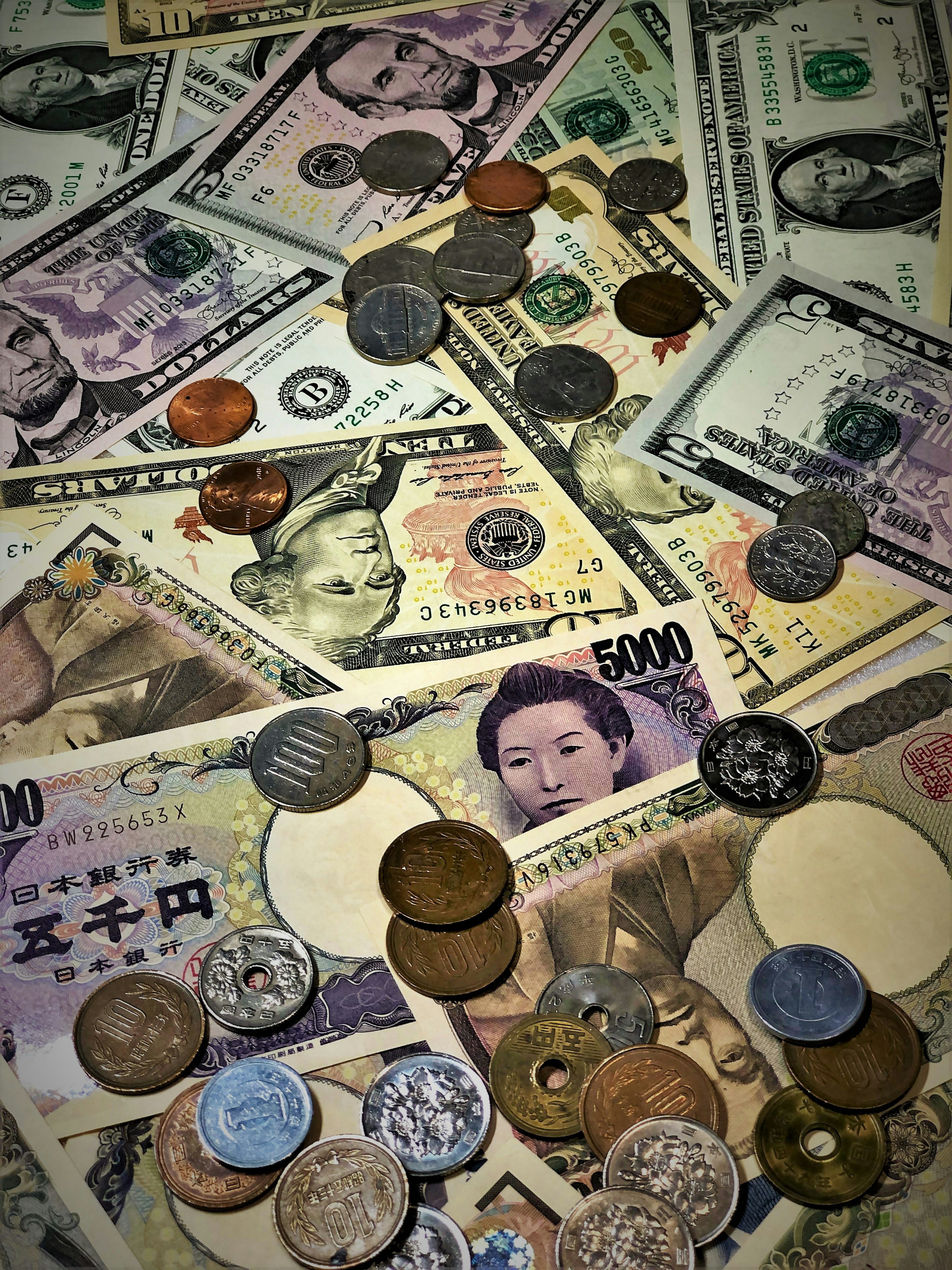 A mix of Japanese yen and US dollar bills along with various coins