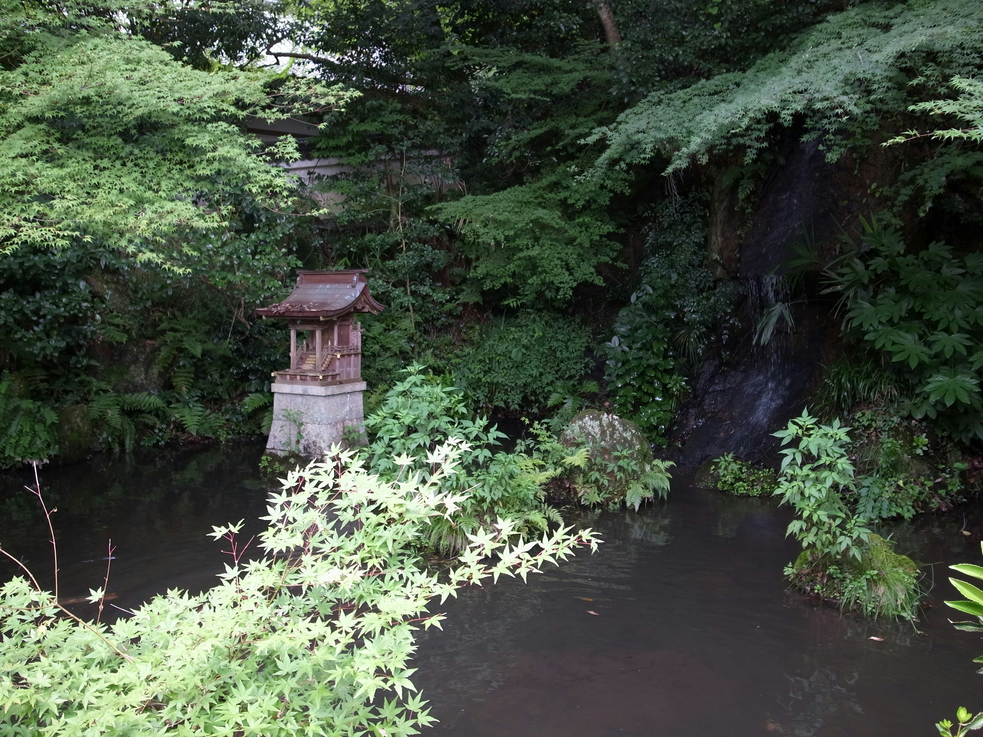 Petite lanterne près d'un étang tranquille entouré de verdure luxuriante