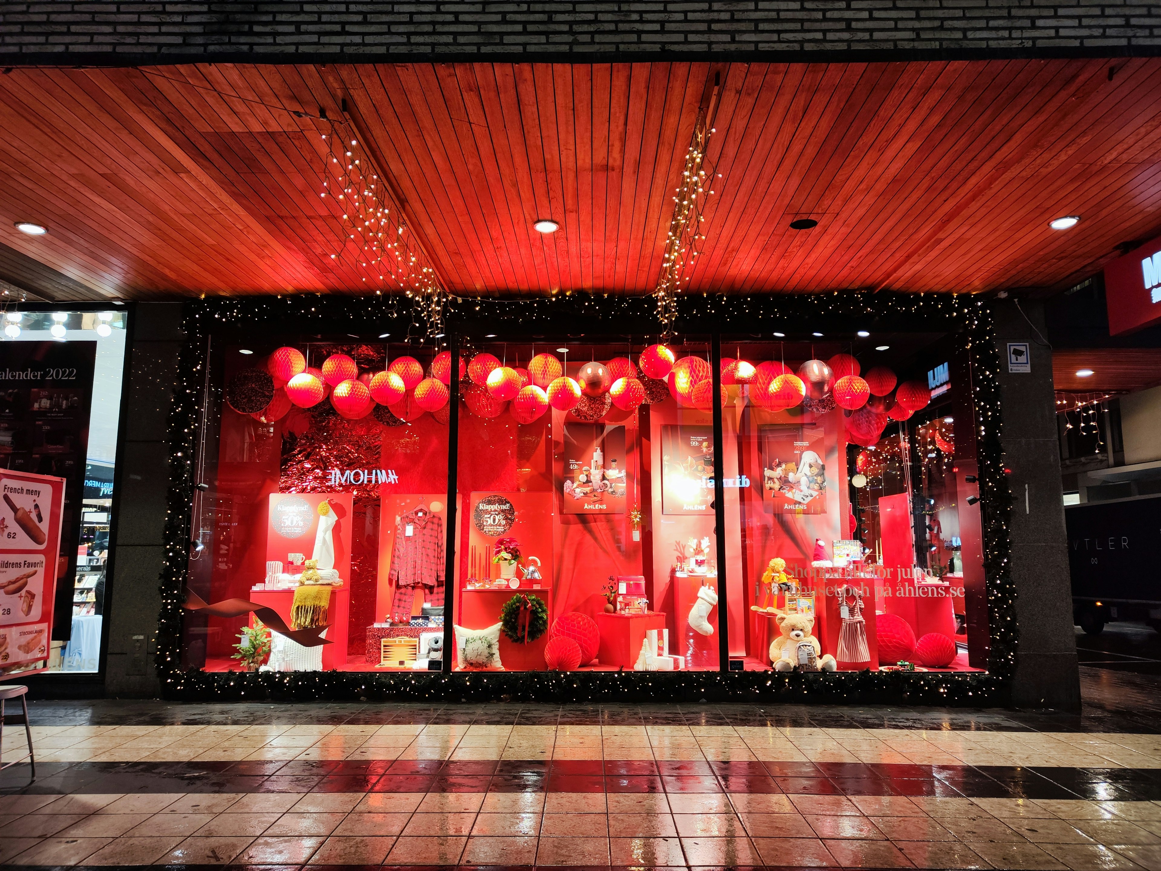 Store window display decorated with red background and lanterns featuring vibrant decorations