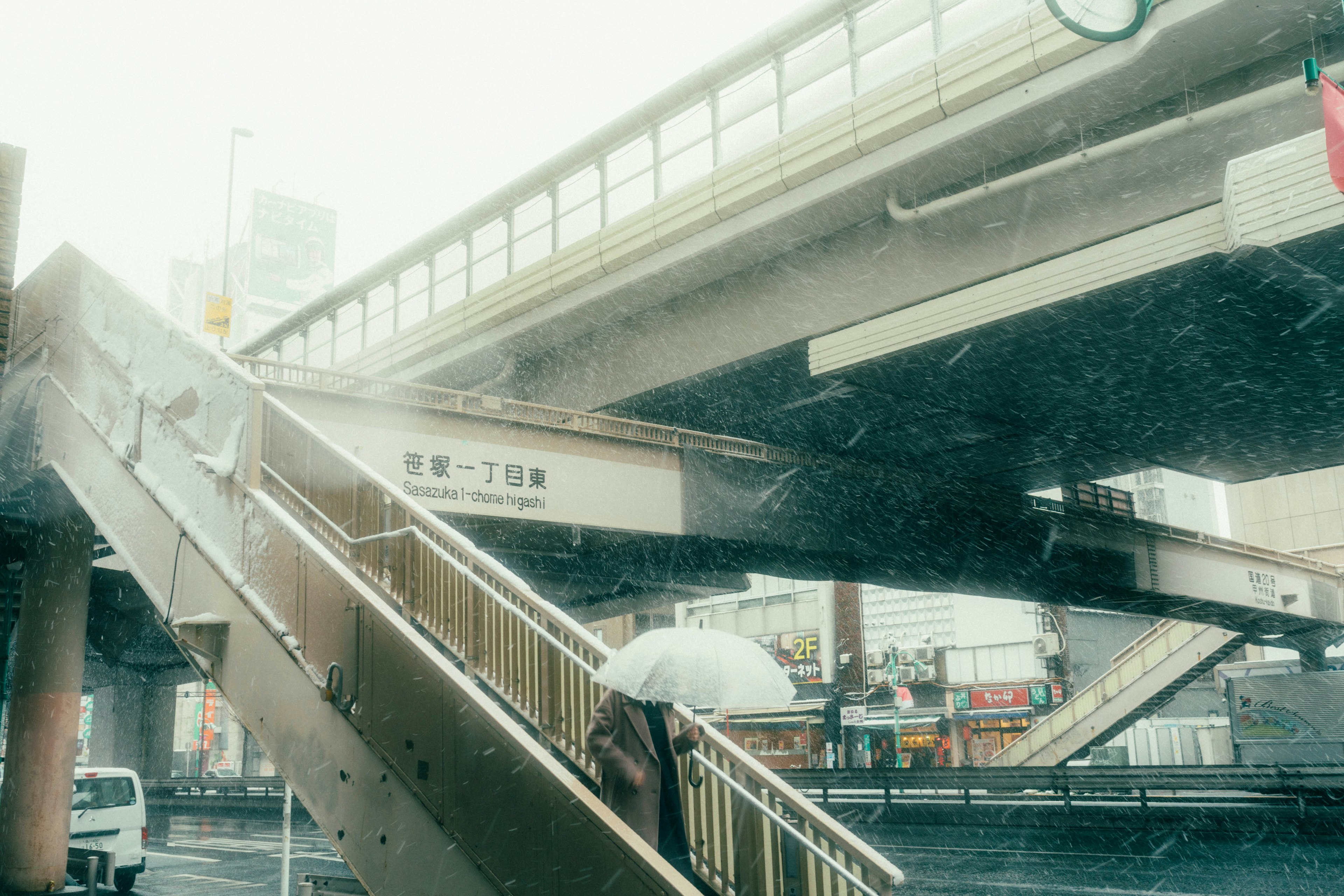 Une scène d'un pont élévateur et d'un escalier sous la pluie avec une personne tenant un parapluie