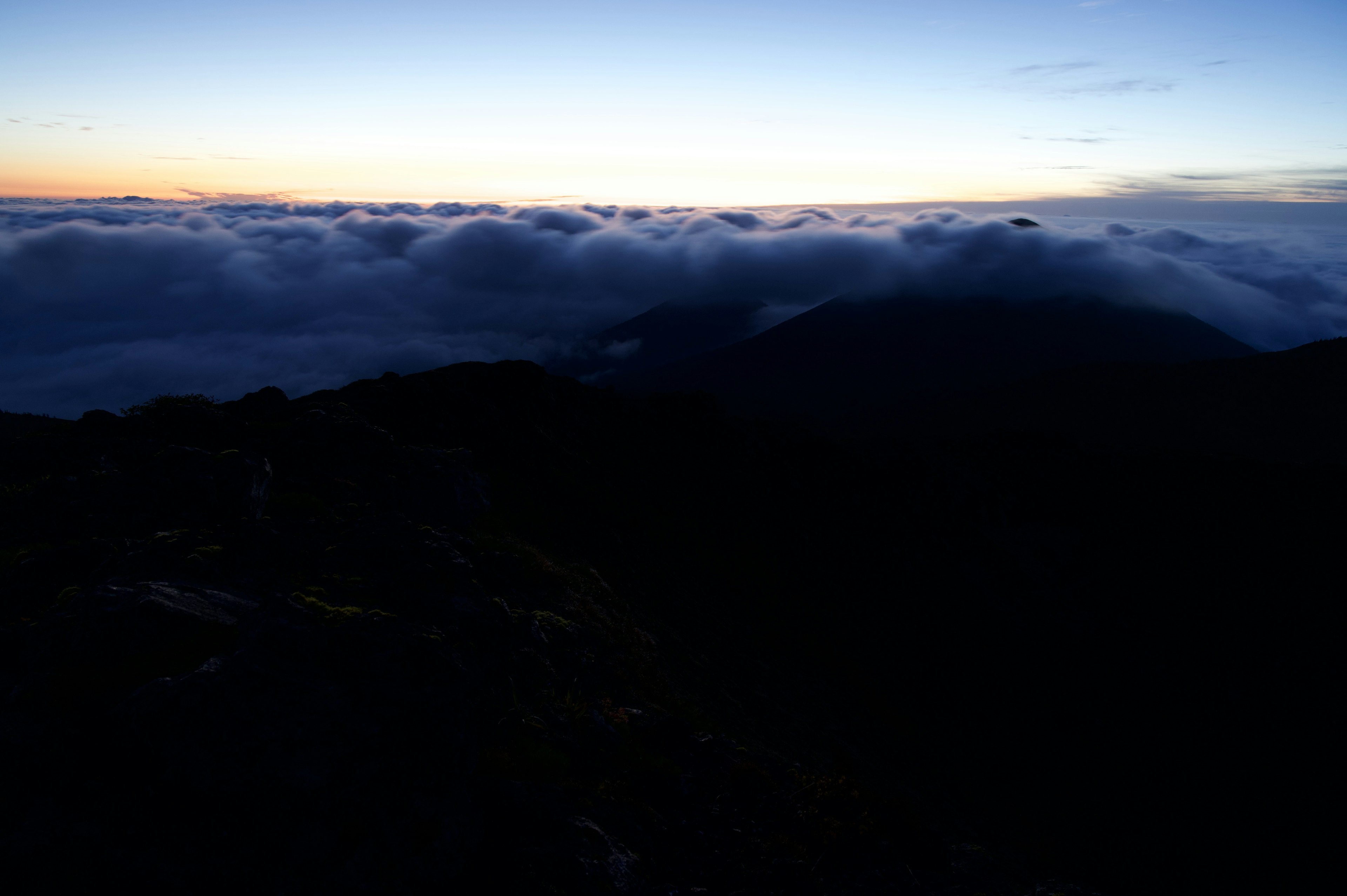 Paesaggio all'alba con un mare di nuvole e montagne