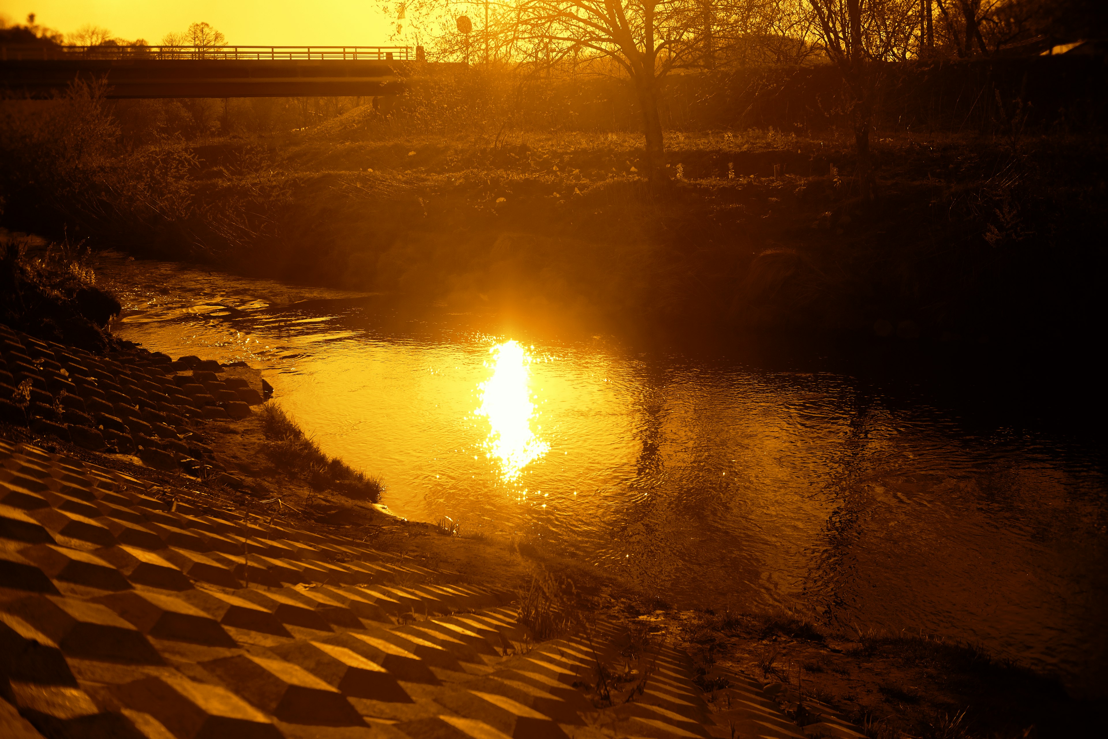 Coucher de soleil doré se reflétant sur l'eau d'une rivière