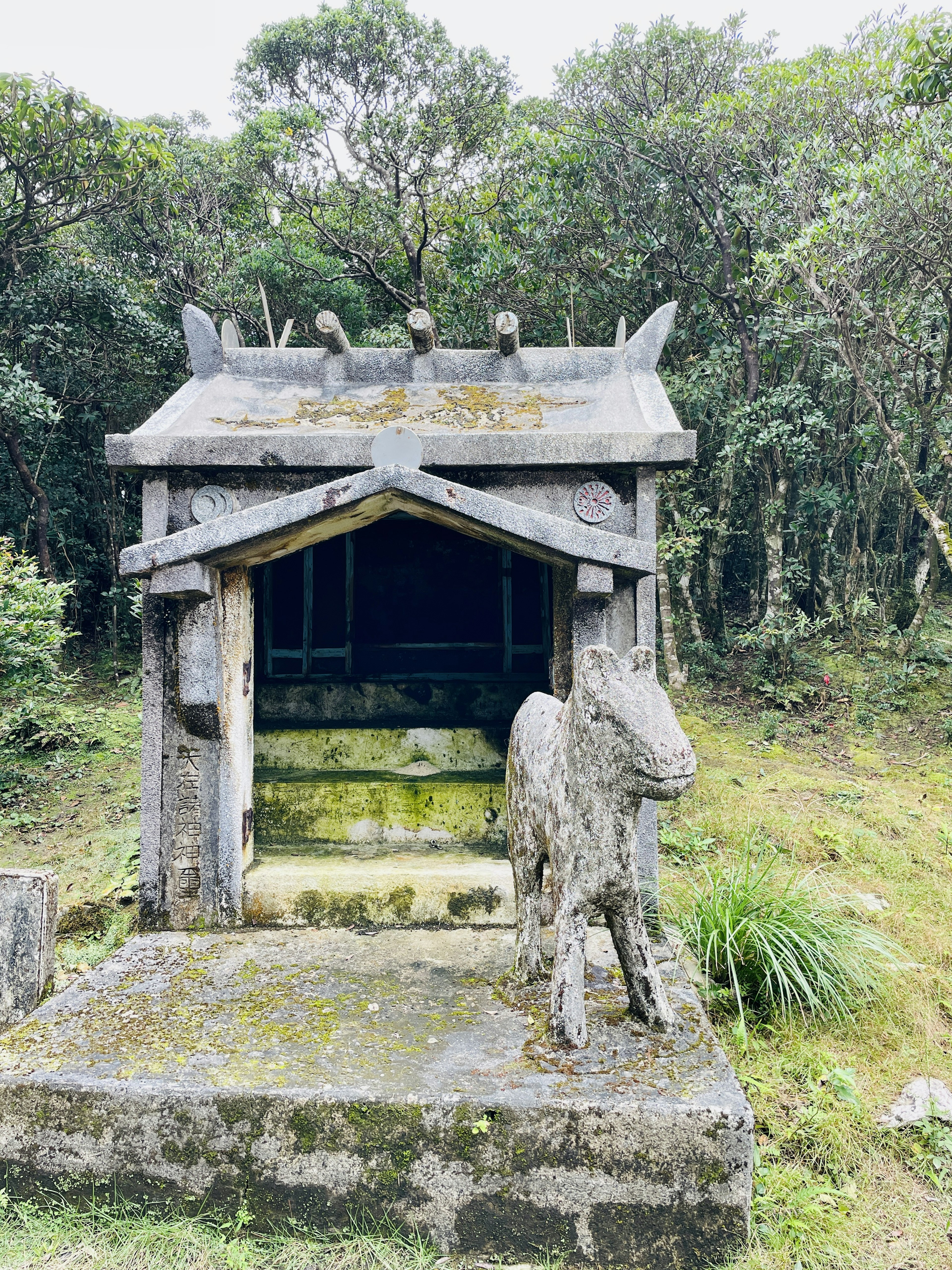 Stone structure resembling a small shrine surrounded by lush greenery