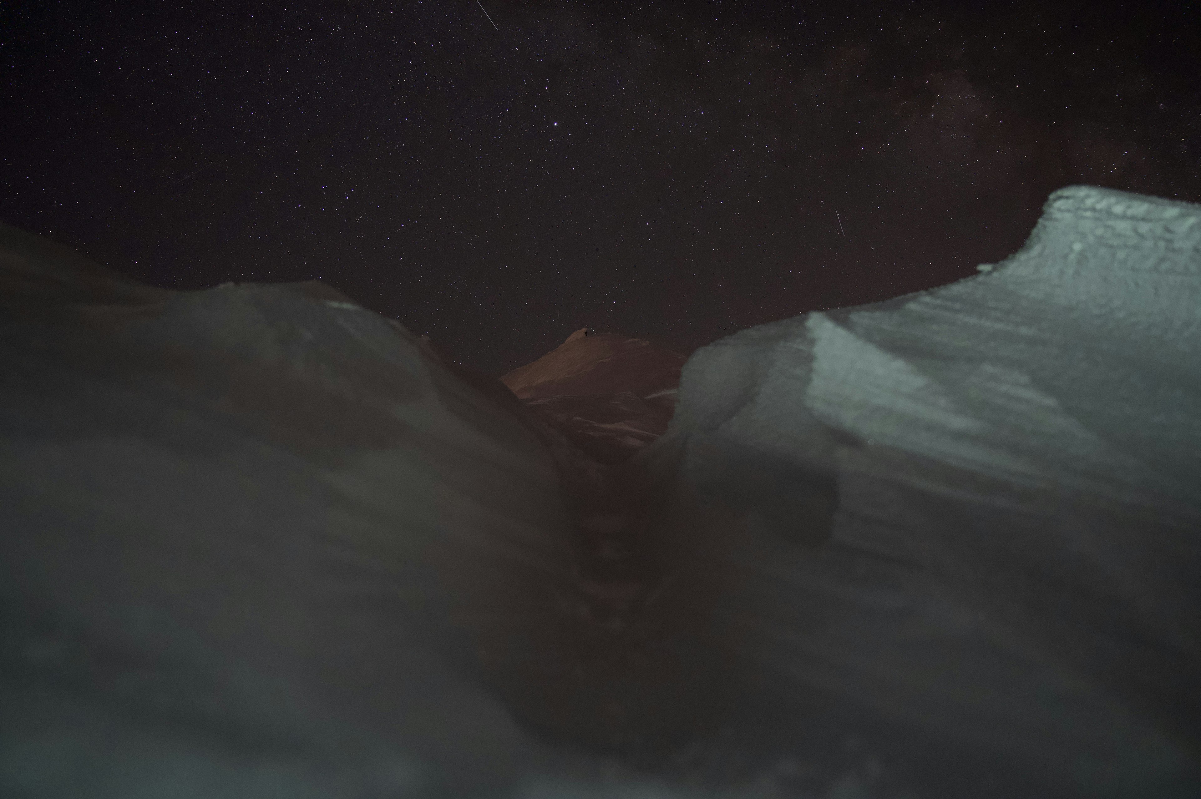 夜空に星が輝く雪山の間の風景