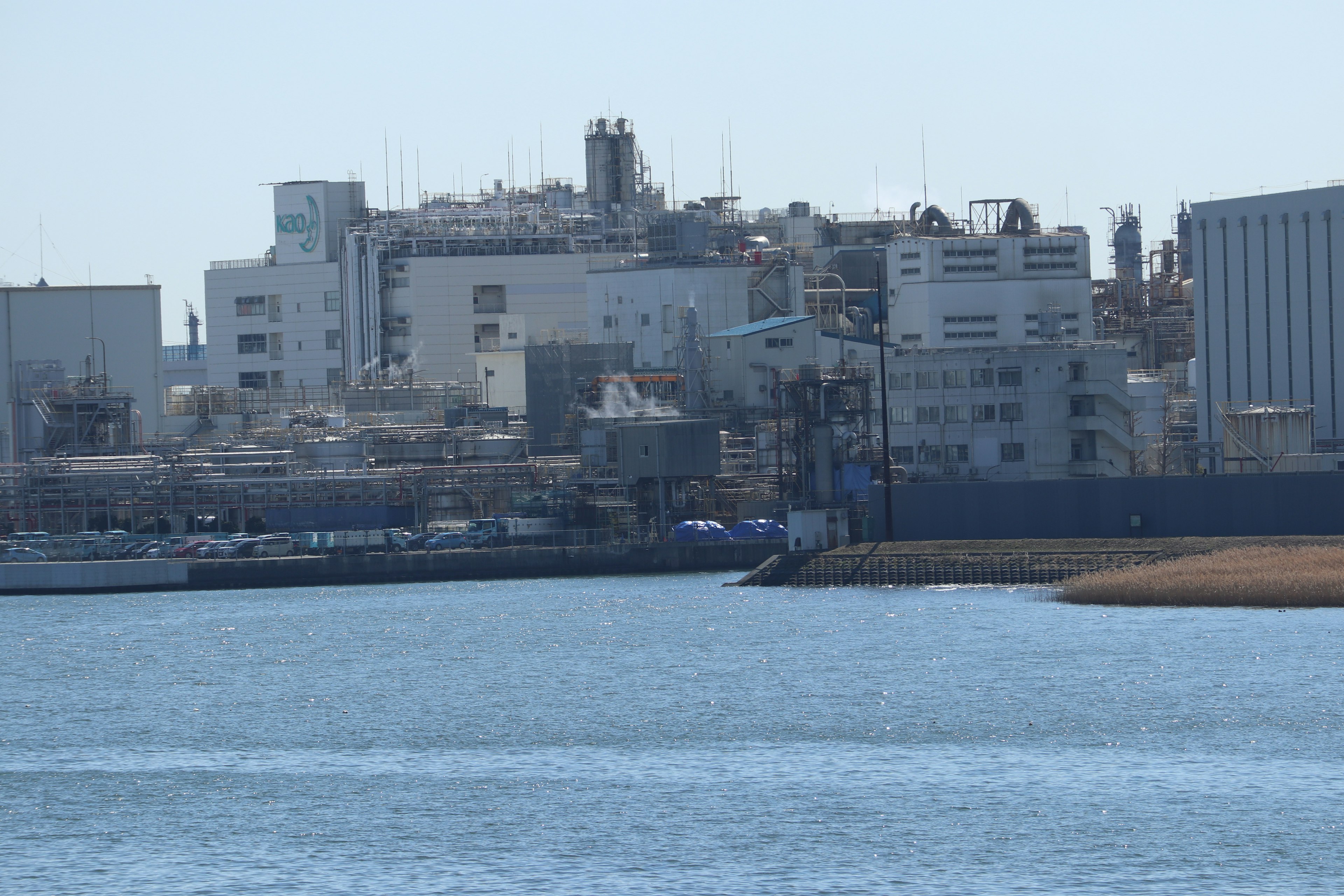 Industrial buildings along the waterfront with blue water