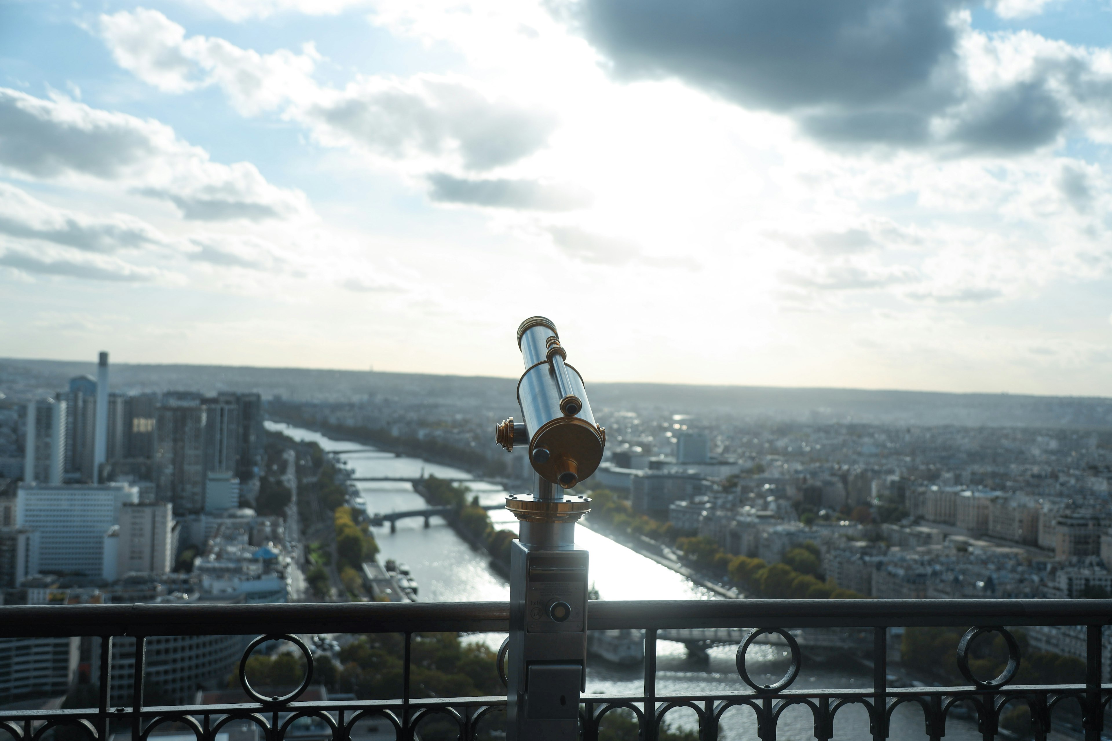 Teleskop auf einer Aussichtsplattform mit Blick auf einen Fluss und die Stadtlandschaft