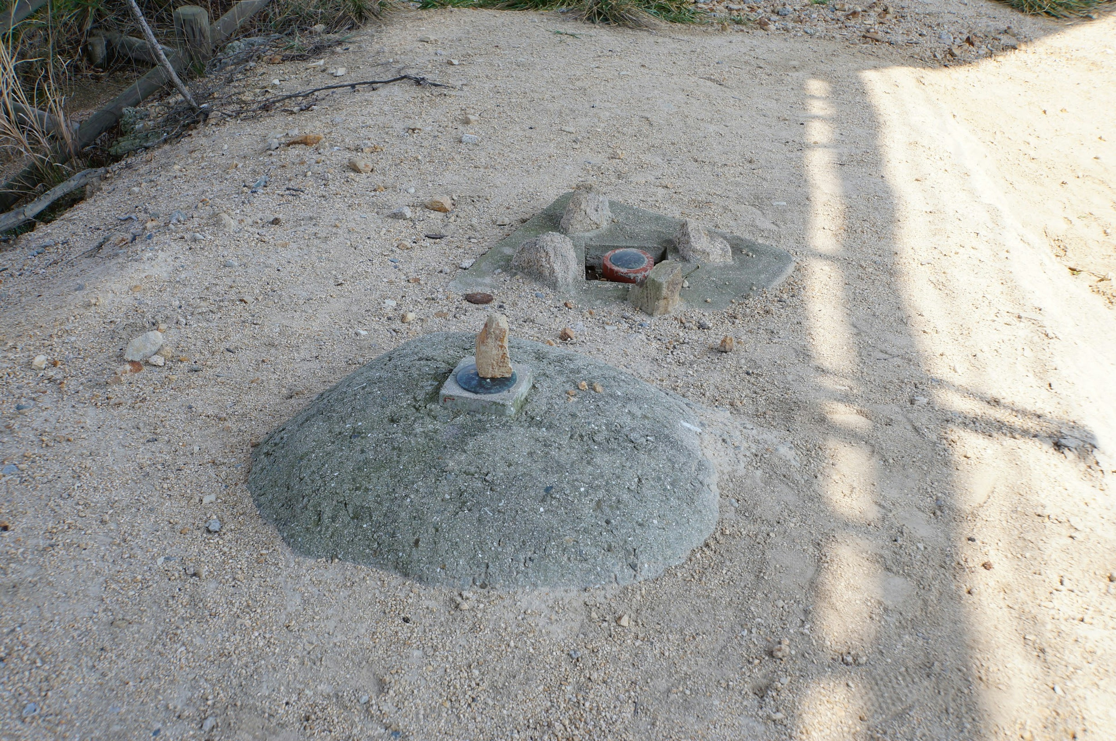 Circular structure made of sand with a small fire pit nearby