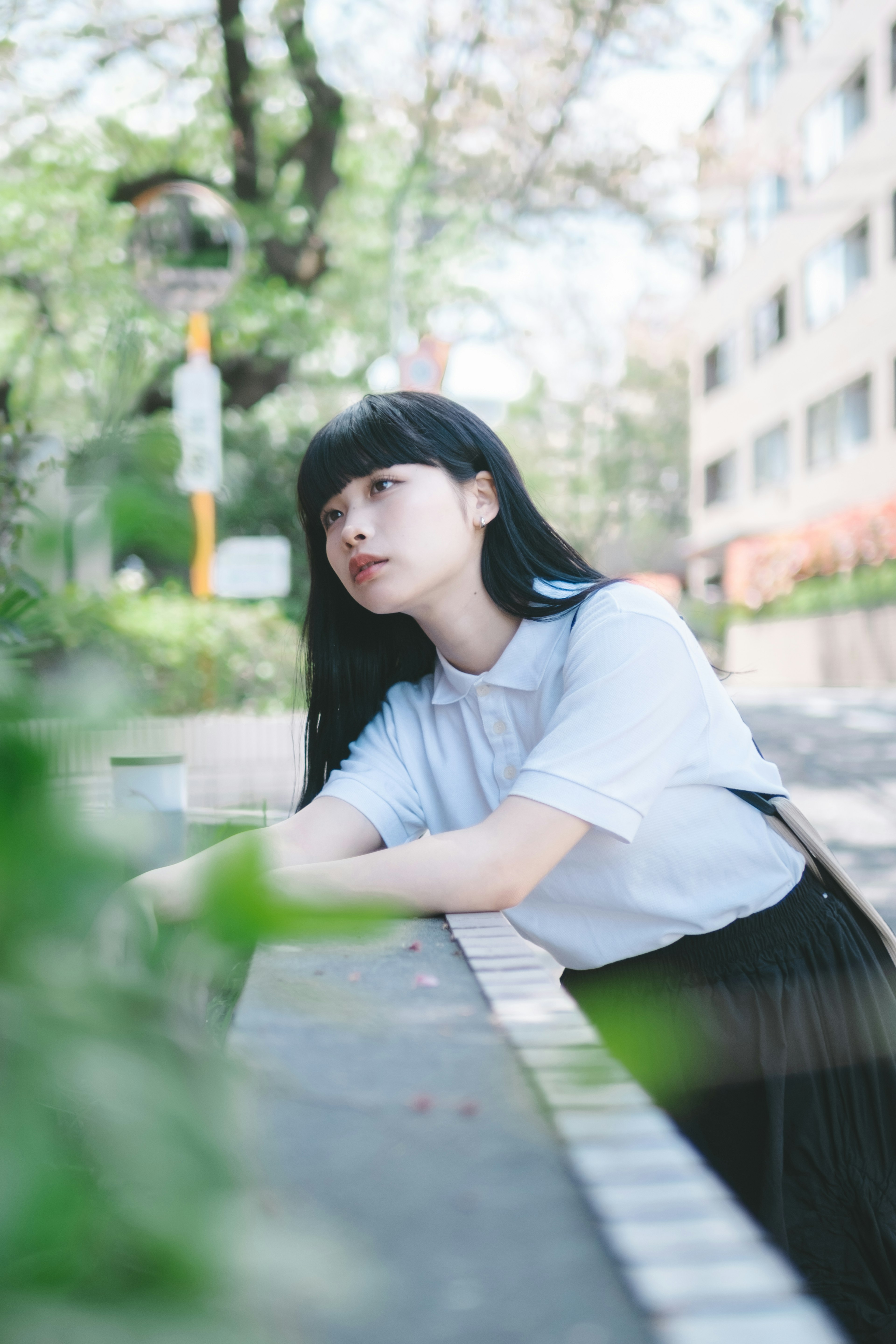 Young woman leaning against a park bench