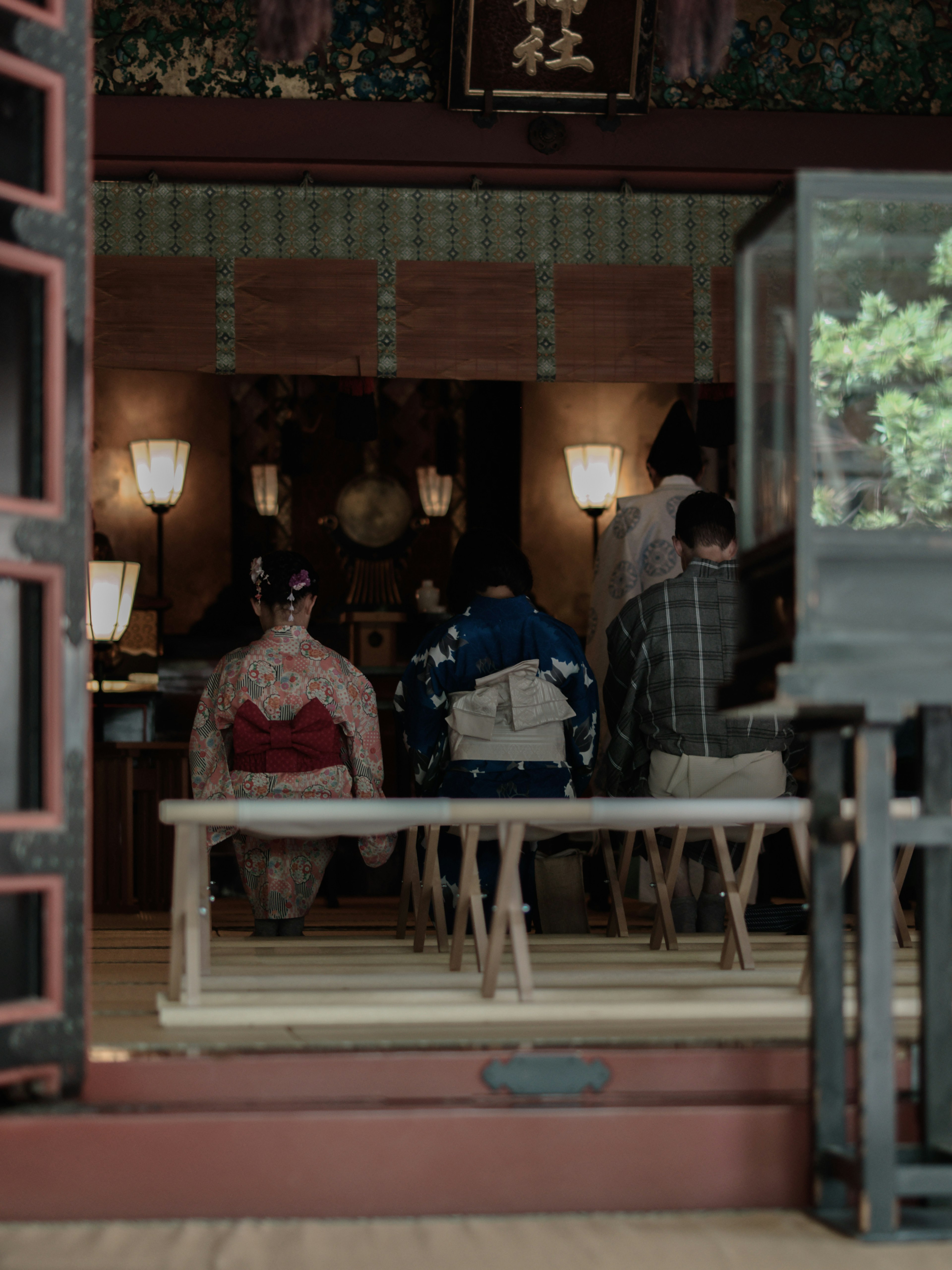 伝統的な和服を着た人々が座っている神社の内部の風景