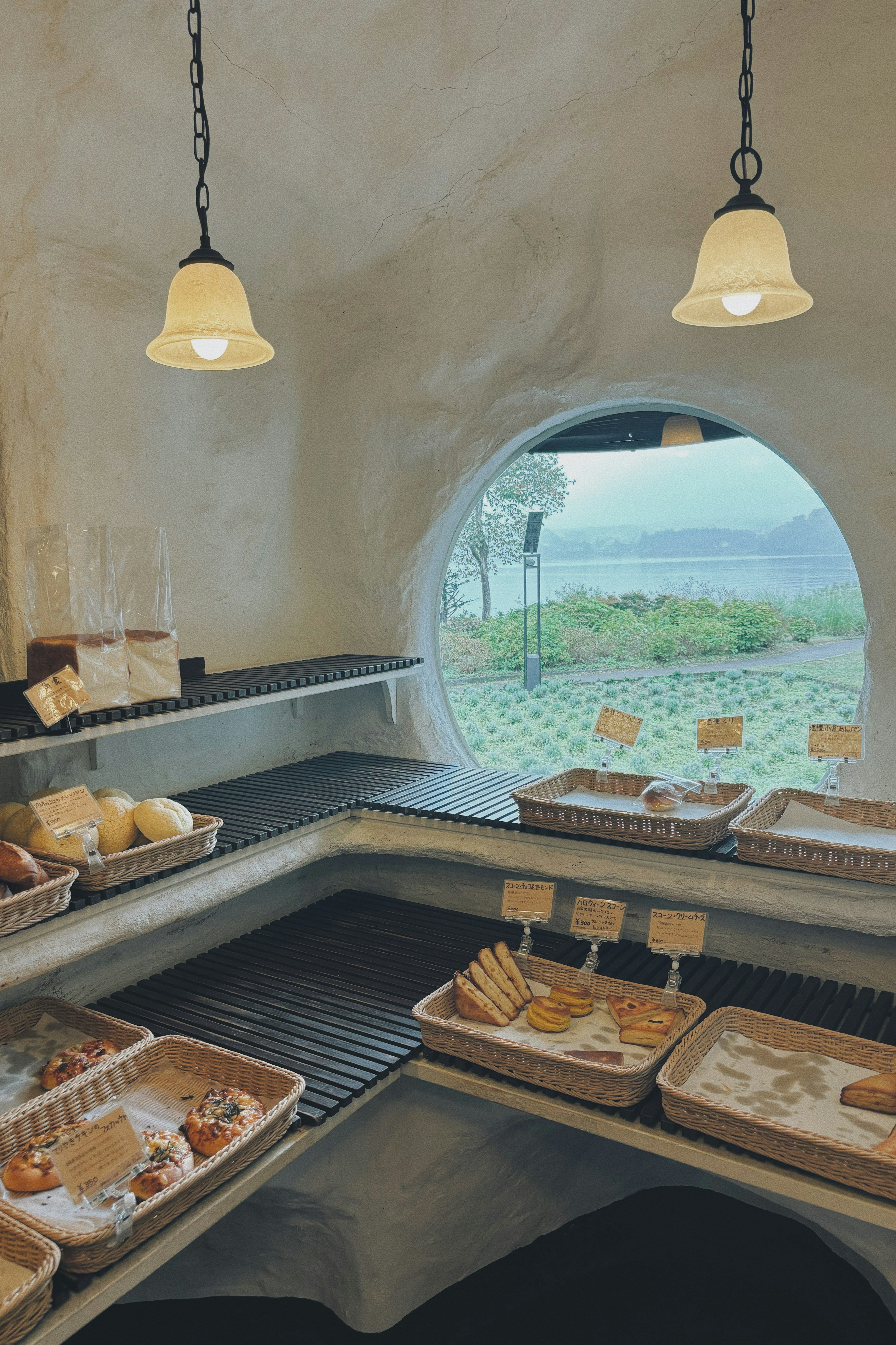 Interior of a bakery with bread displayed and a round window view