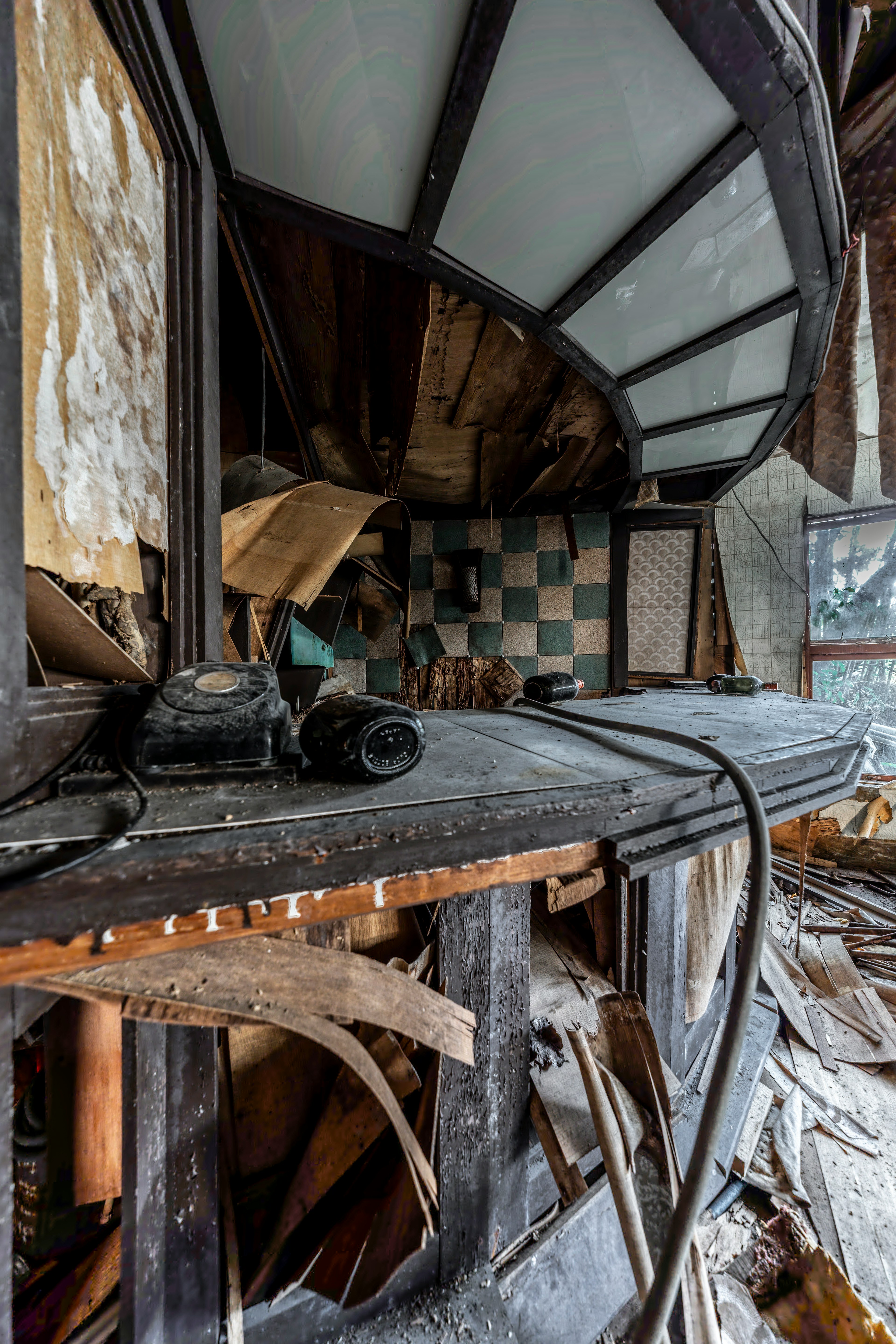 Interior de un espacio abandonado con un teléfono antiguo y un mostrador desgastado