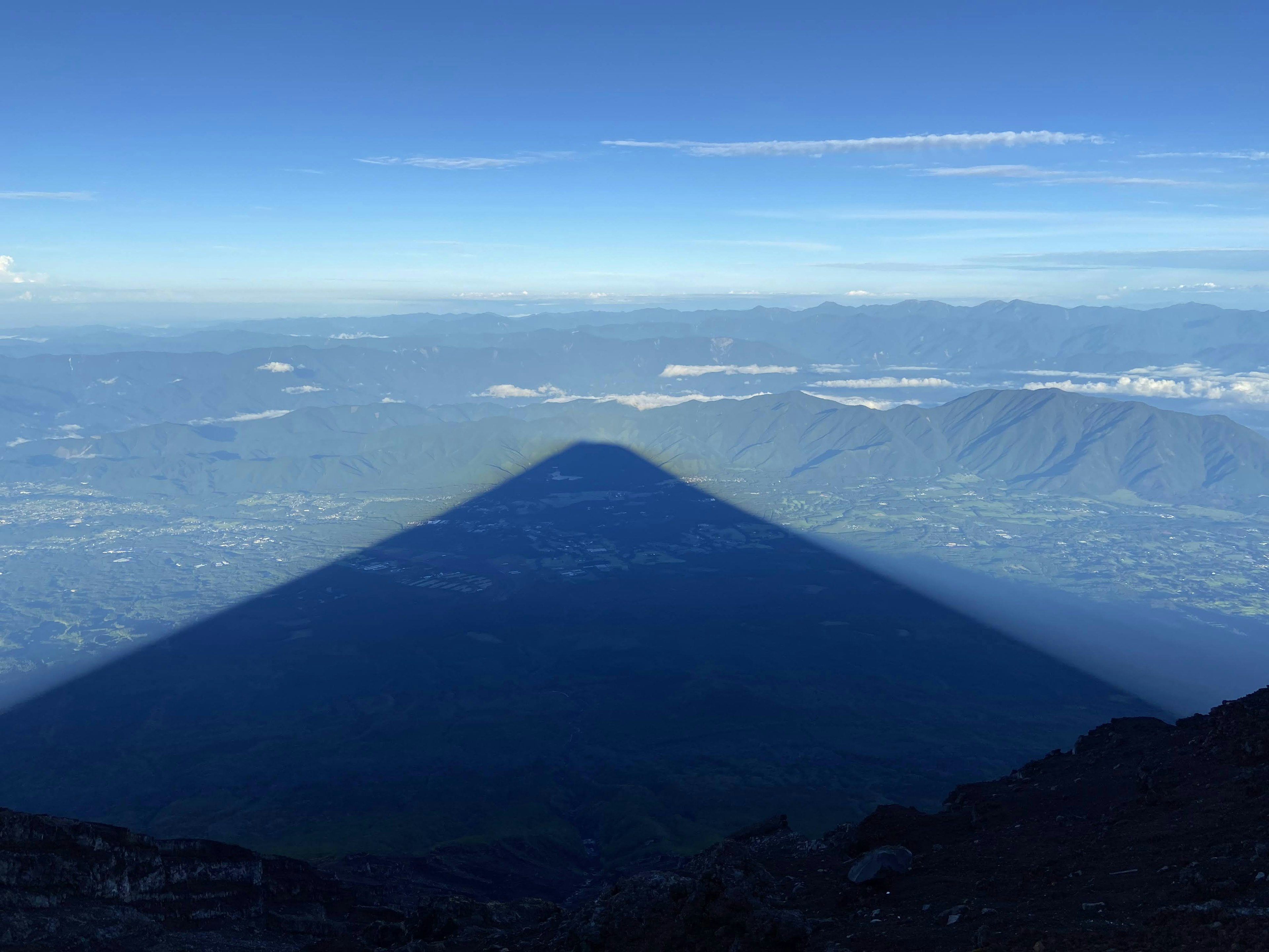 เงาภูเขาขยายไปทั่วภูมิทัศน์ที่สวยงามท้องฟ้าสีฟ้าและเมฆ