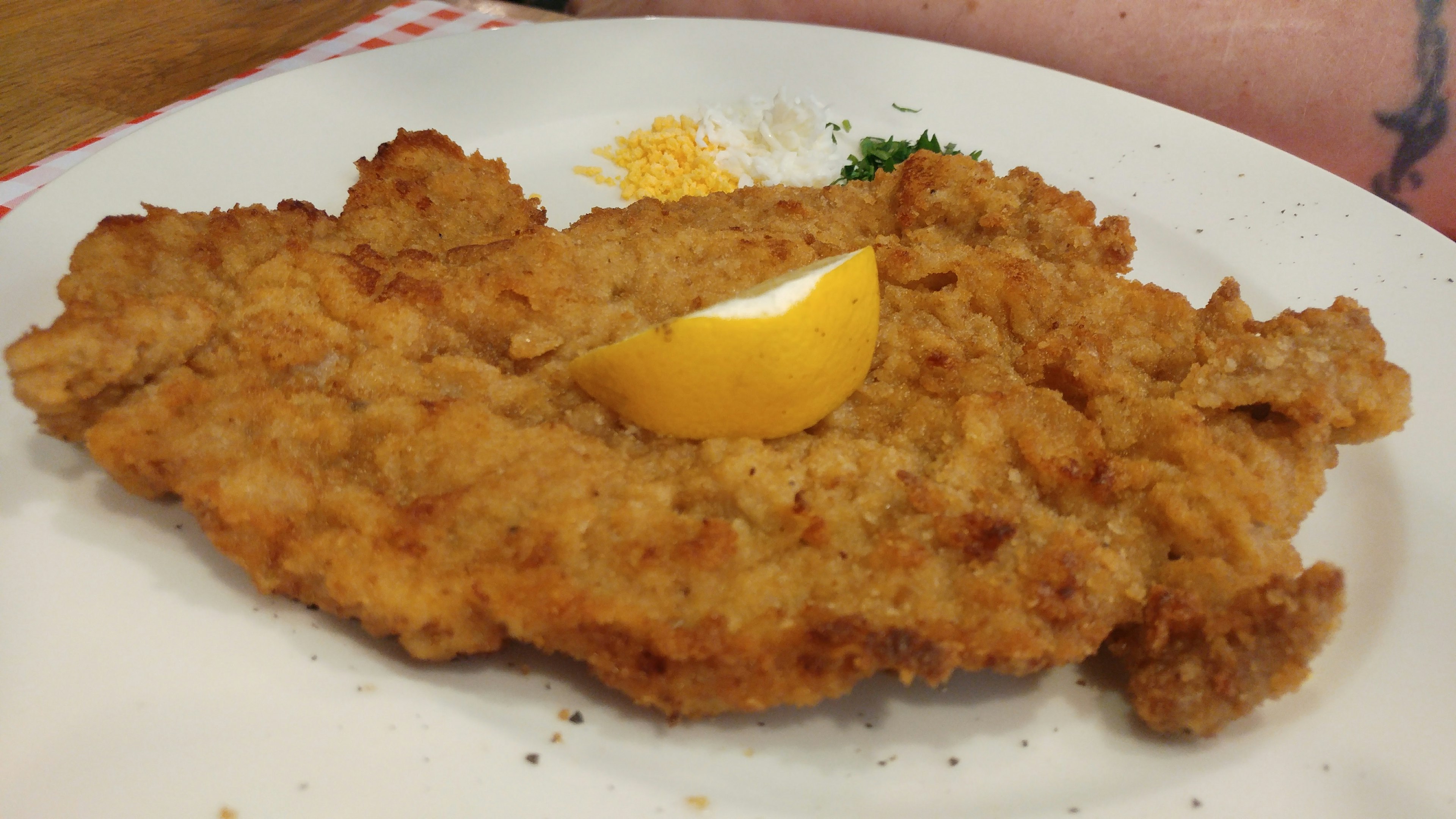 Cotoletta di pollo fritta decorata con una fetta di limone