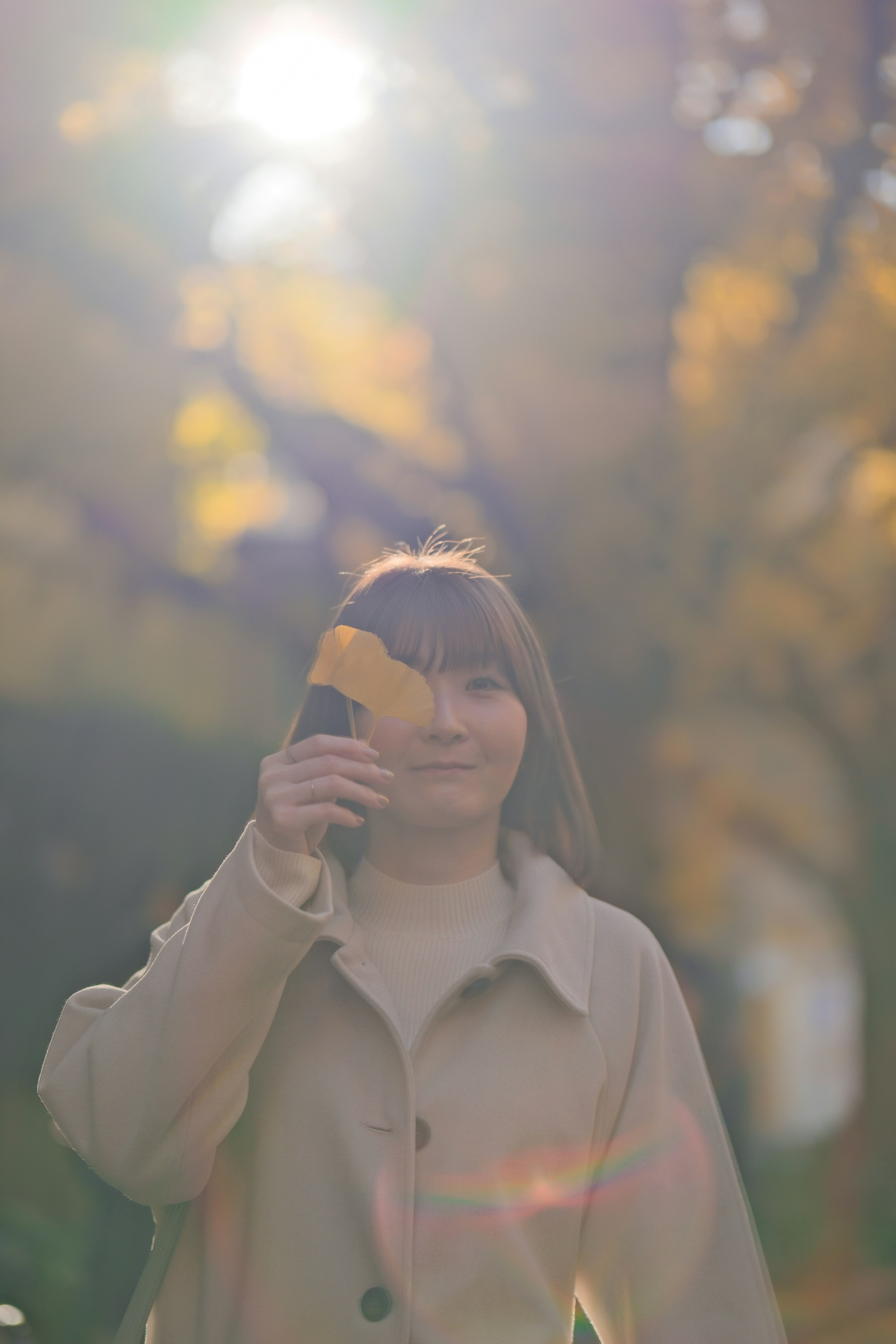 秋の風景の中で葉を持つ女性の柔らかな表情