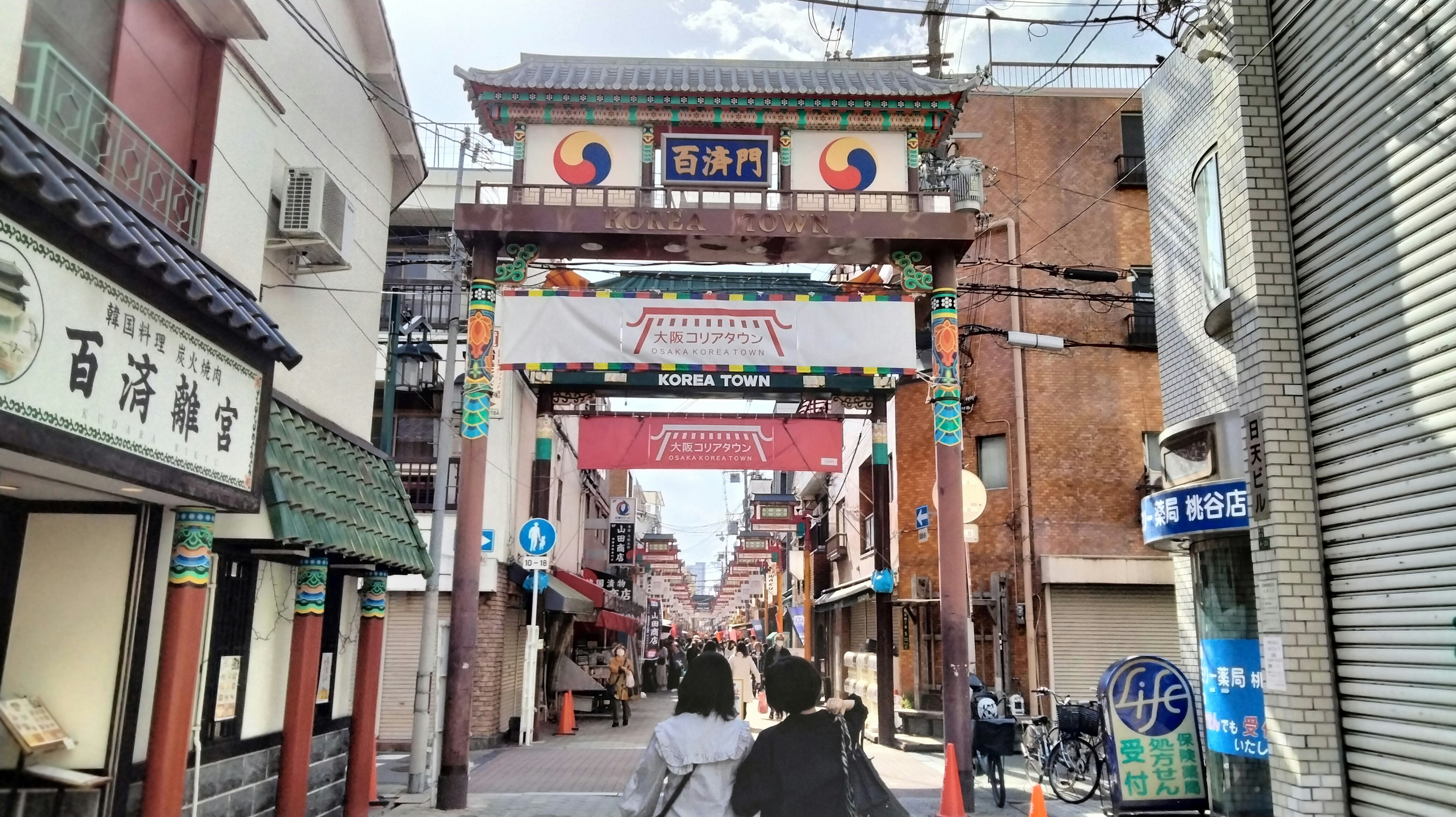 Traditional gate in a lively street showcasing Korean cultural elements