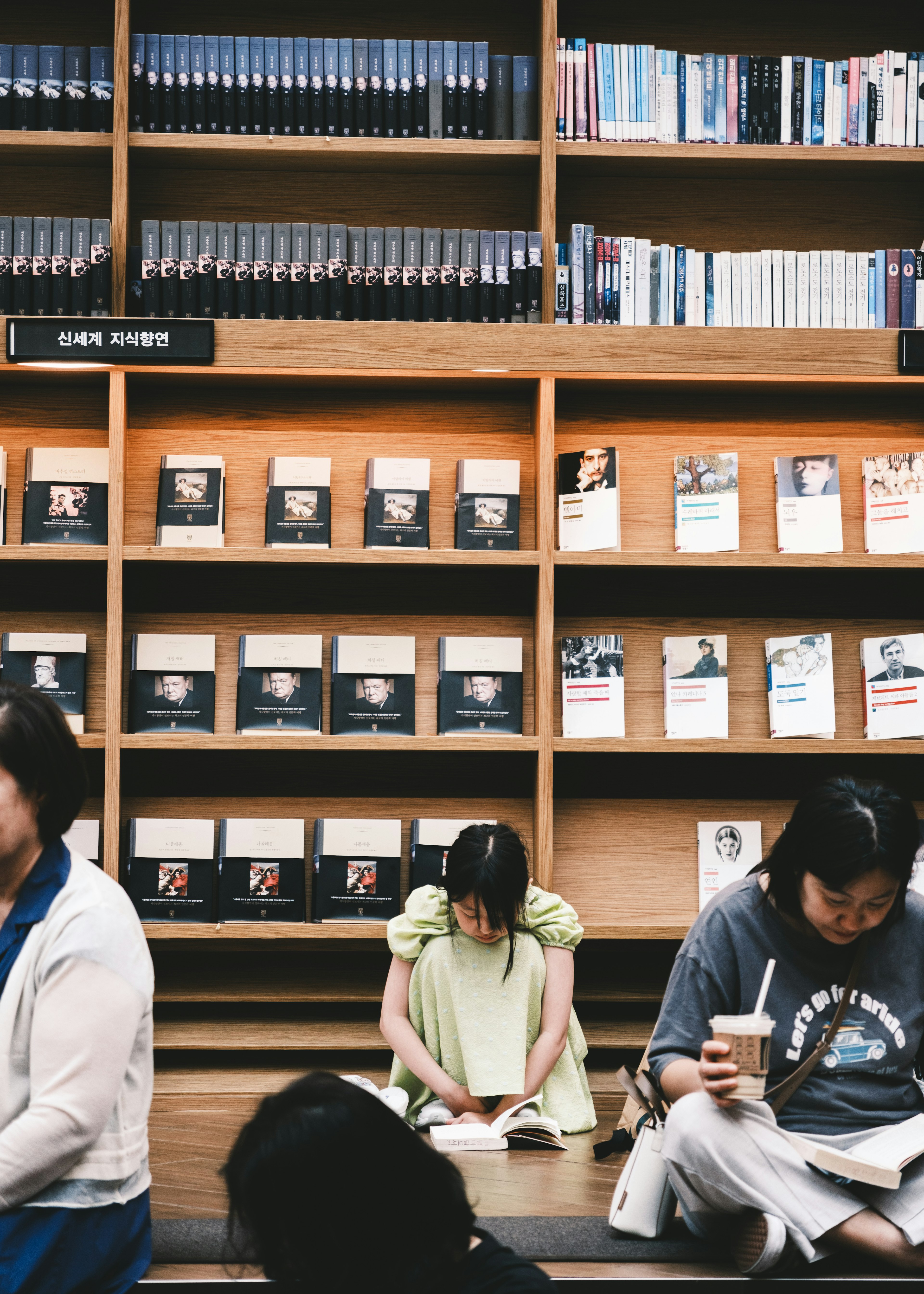 Image of people reading in a library with bookshelves