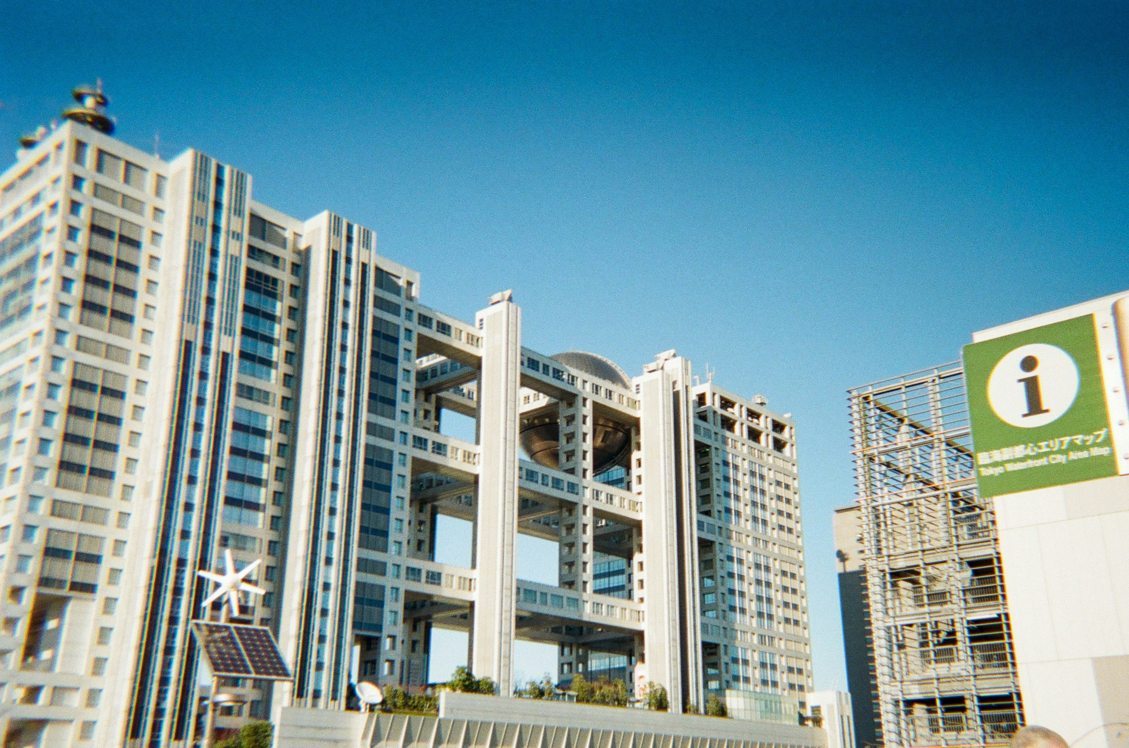 Design architettonico unico di un edificio sotto un cielo blu chiaro con un'insegna informativa