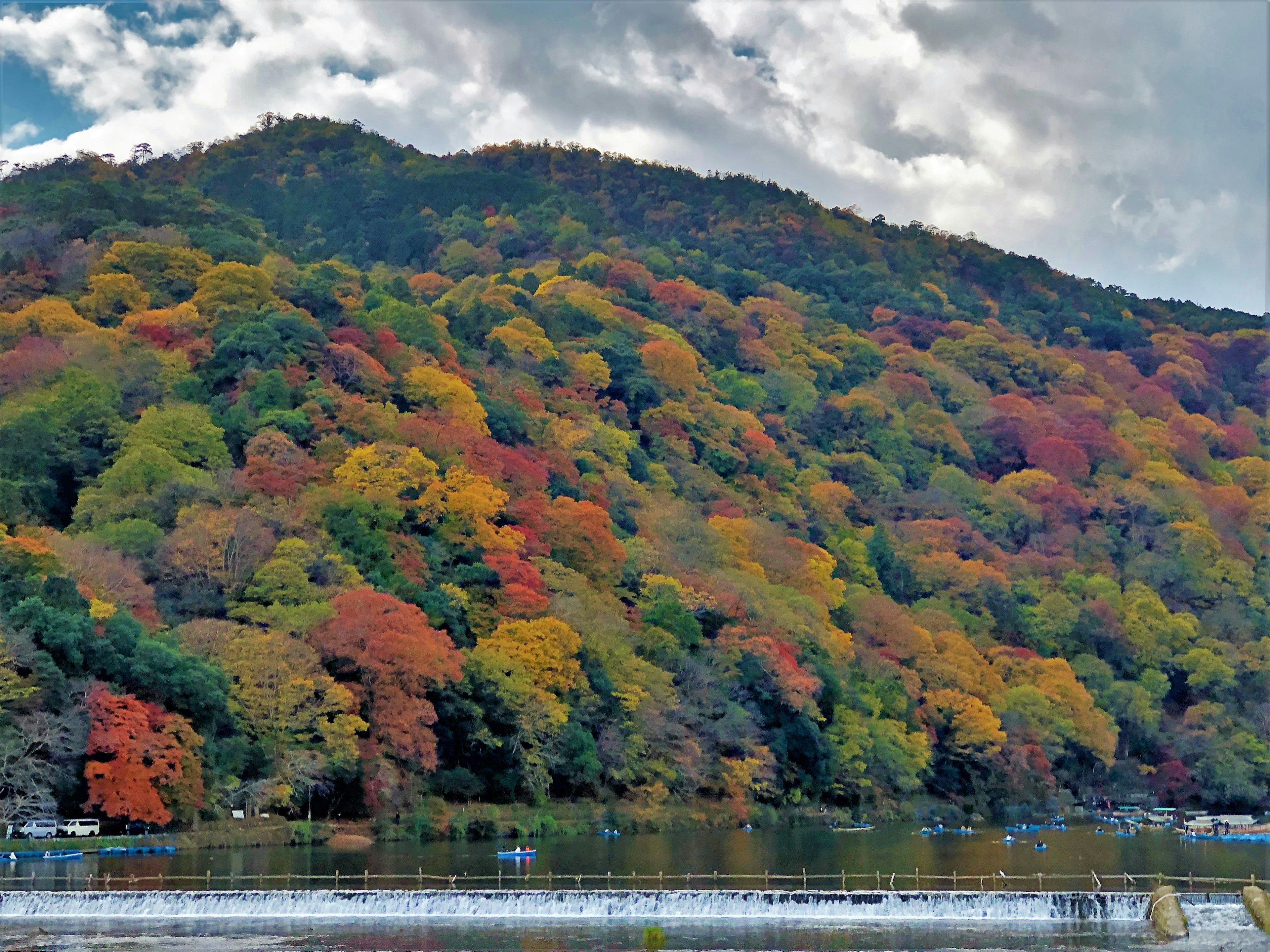 Vibrant autumn foliage covering a hillside by a lake