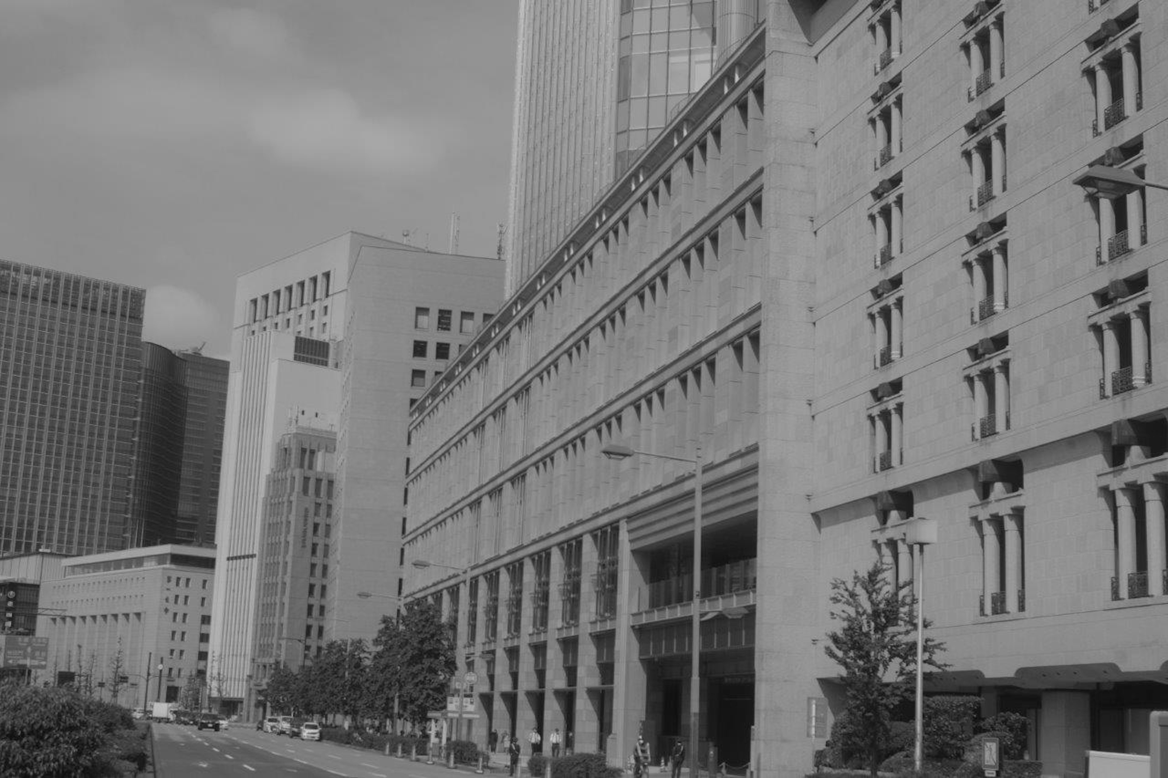 Black and white photo featuring building facades and city street