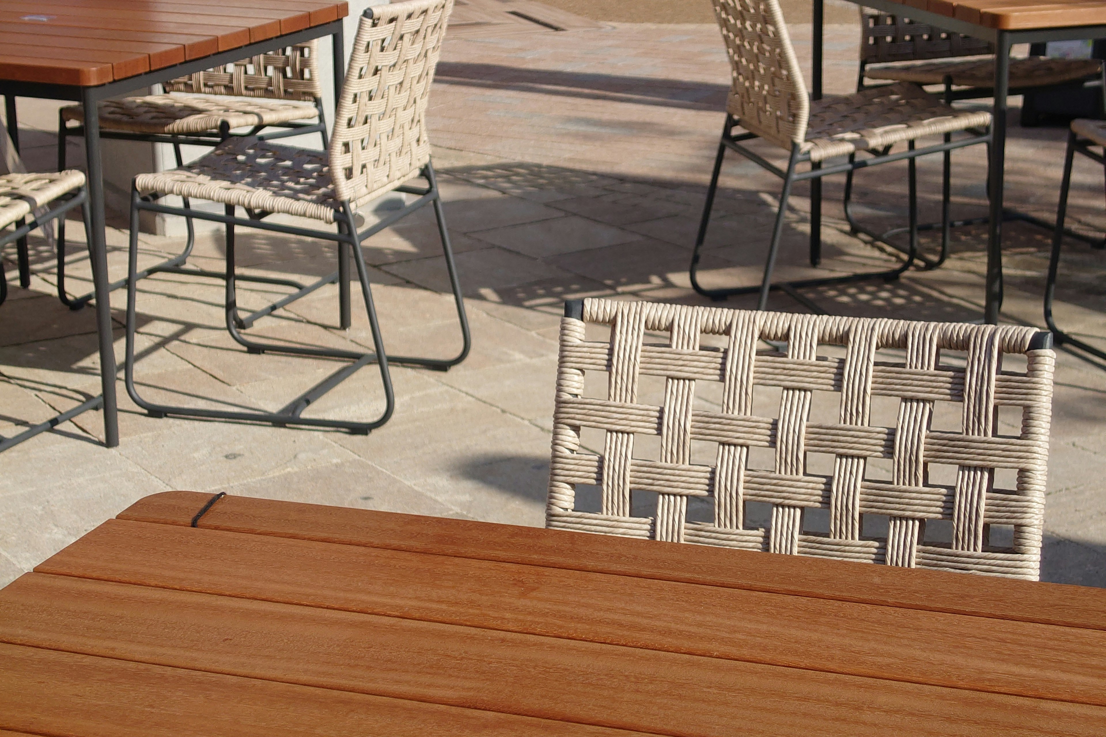 Outdoor dining area with wooden table and mesh chairs