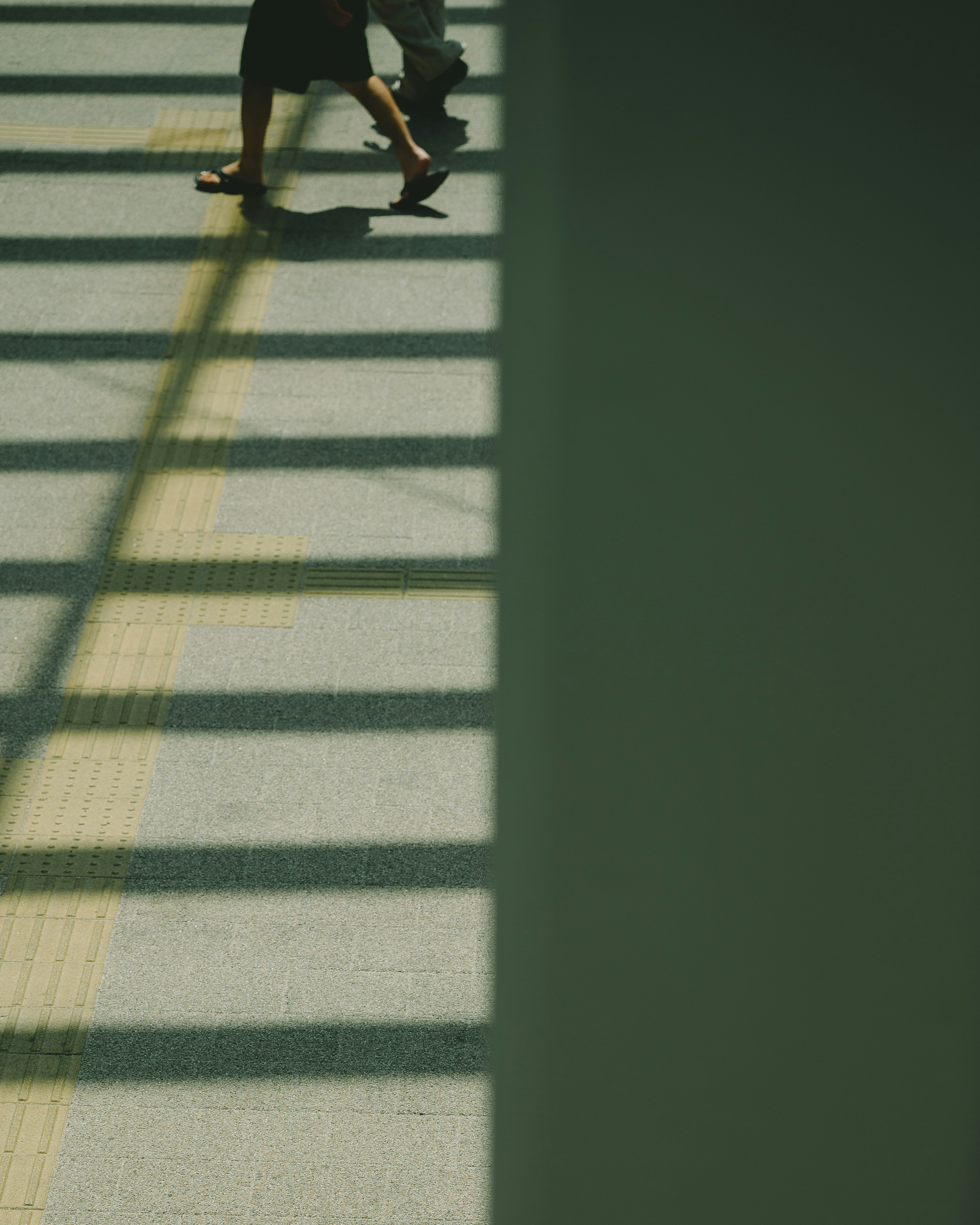 Une personne marchant dans l'ombre avec des rayures distinctes au sol