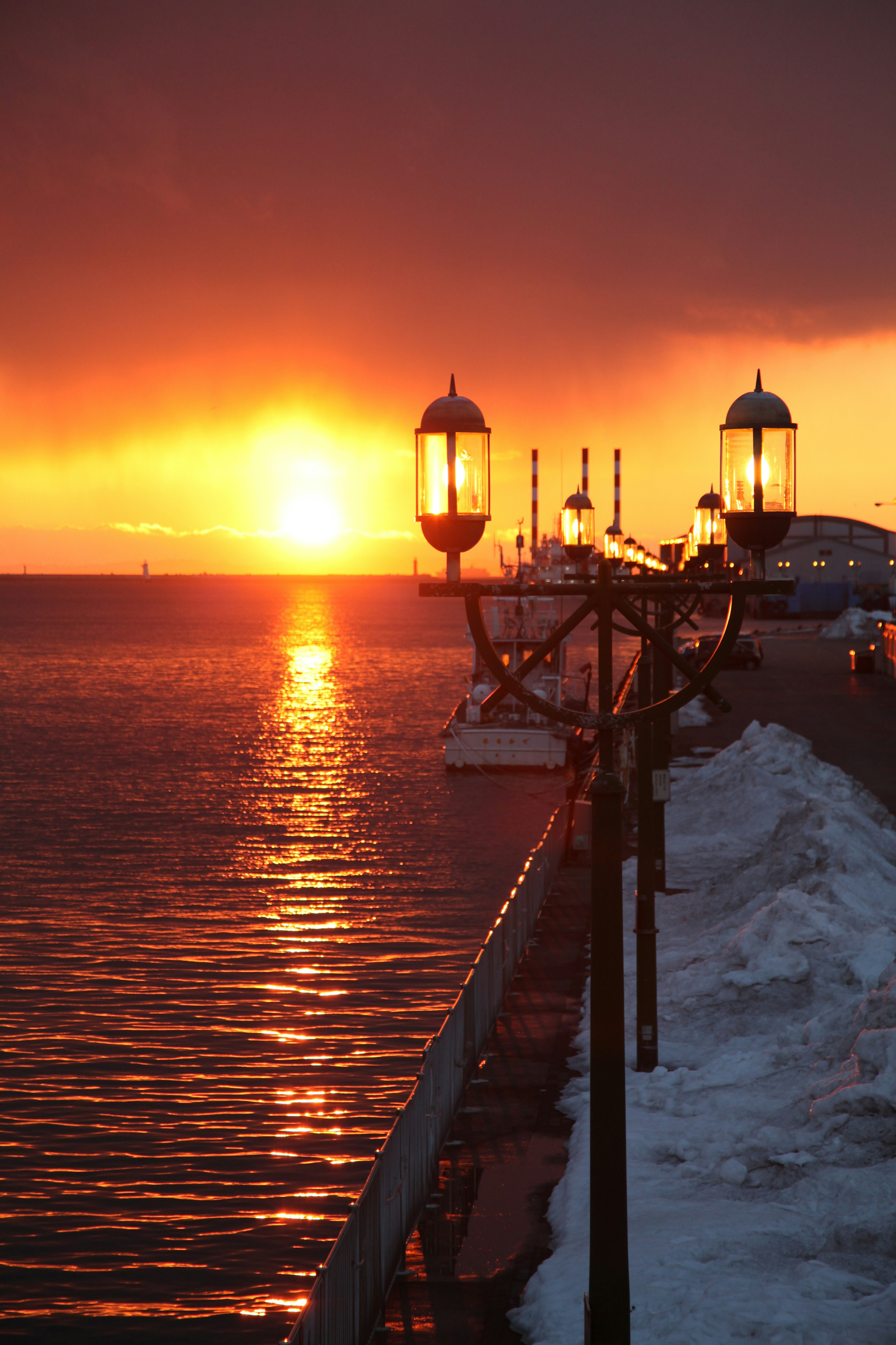 Un quai au coucher du soleil avec des lanternes lumineuses et des couleurs vives