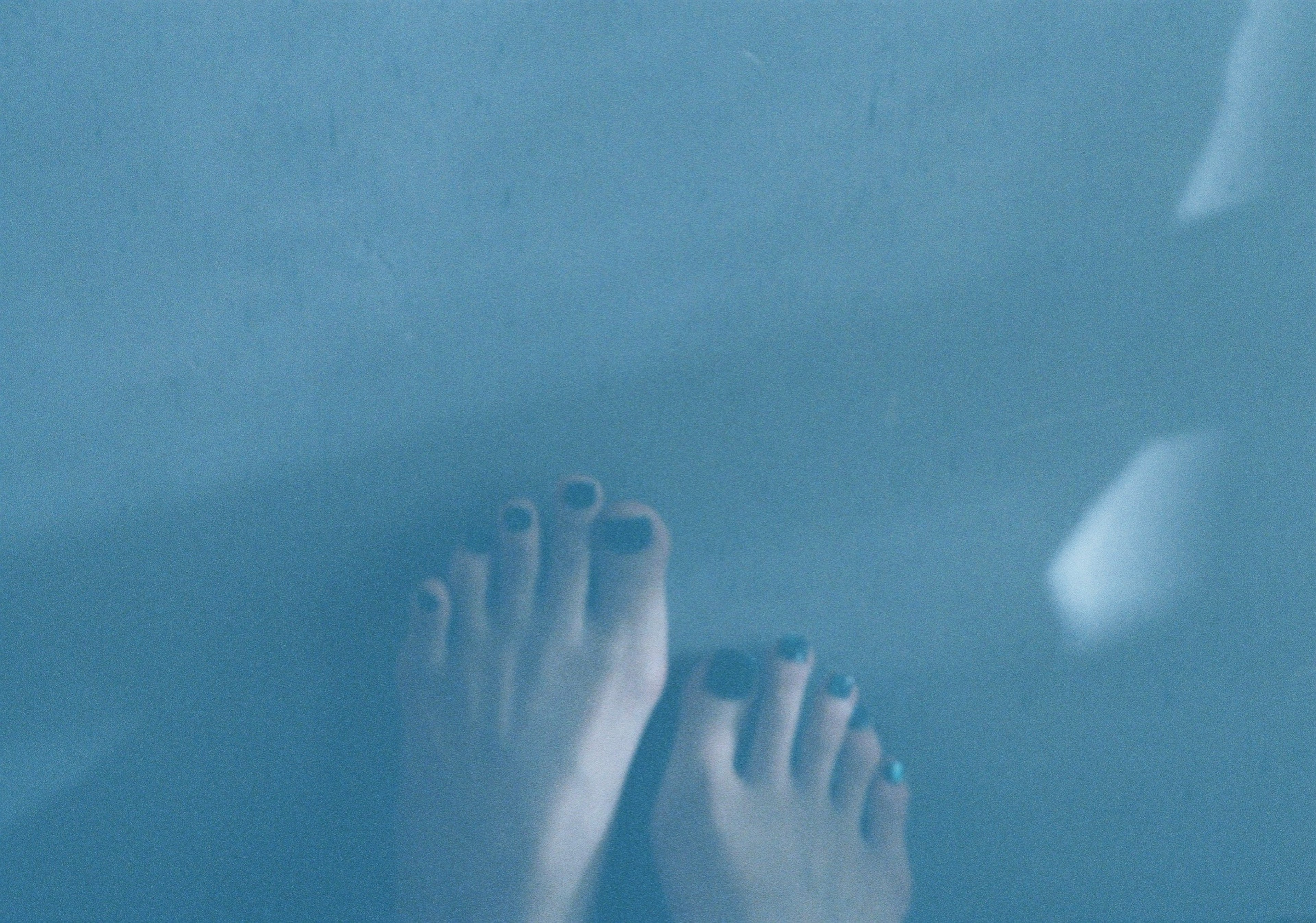 Photo of bare feet on a blue surface