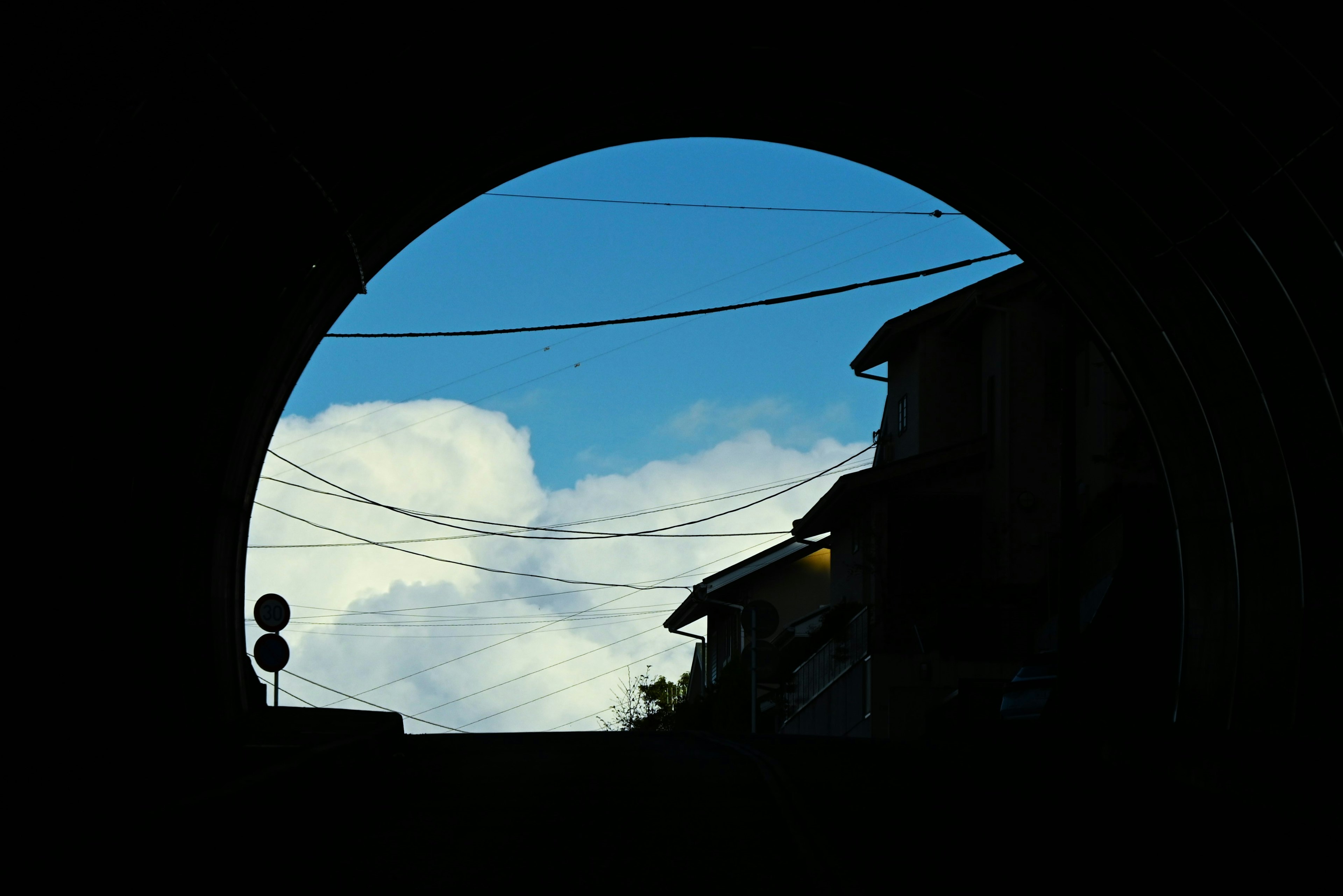 Silueta de edificios y nubes vistas desde la abertura de un túnel