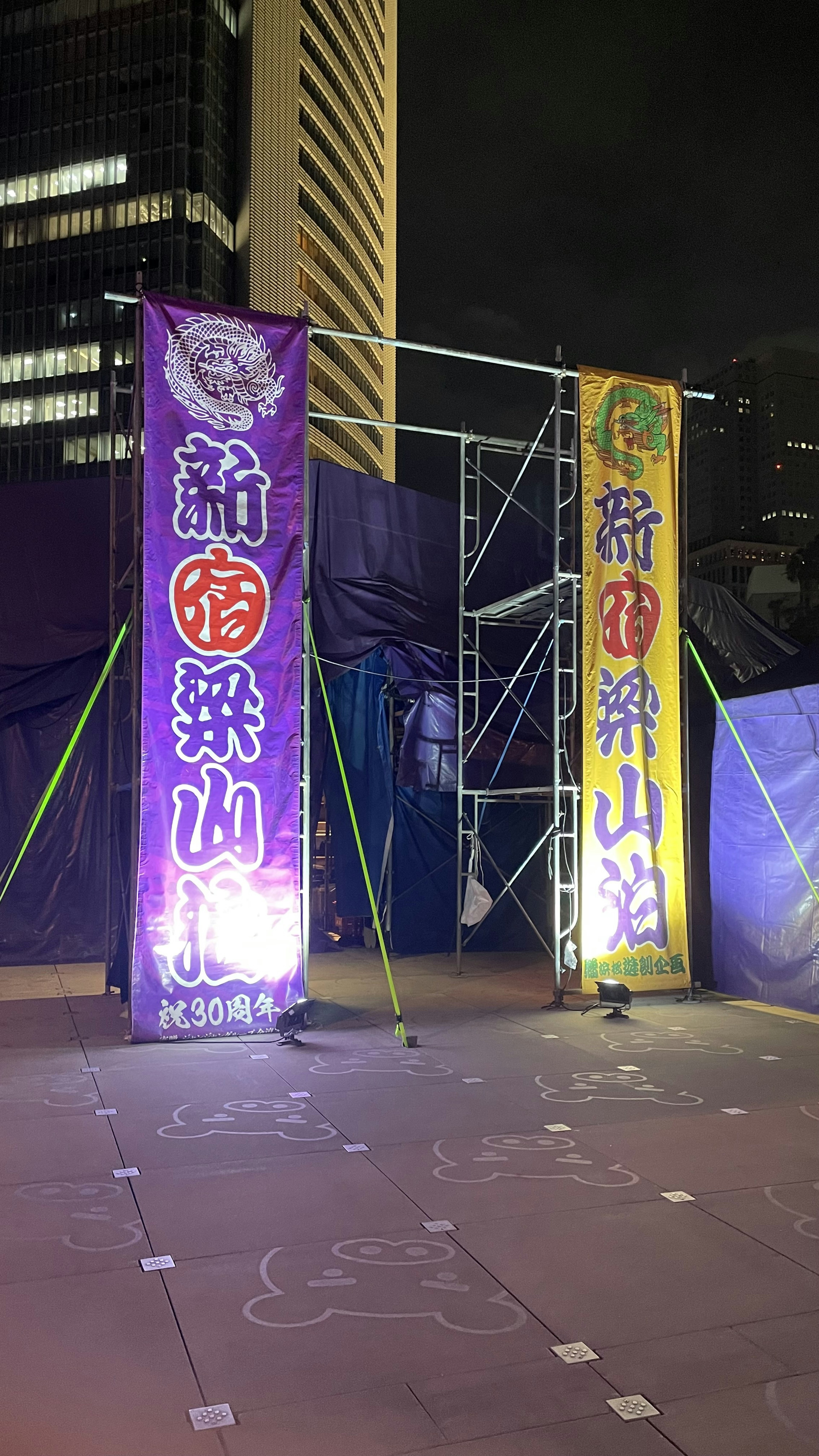 Banderas coloridas y andamios en un entorno urbano nocturno