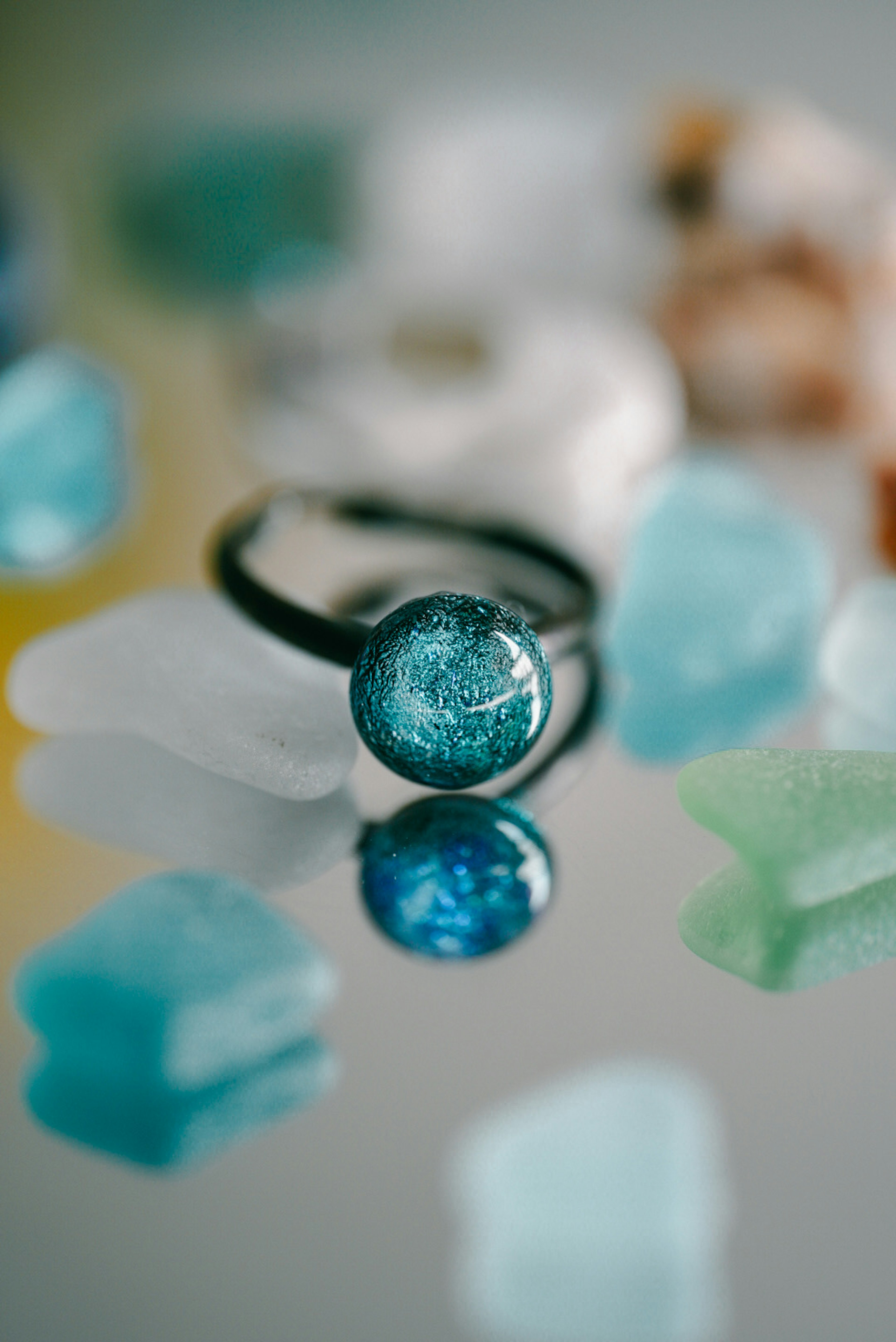 A blue glass ring placed on colorful gemstones