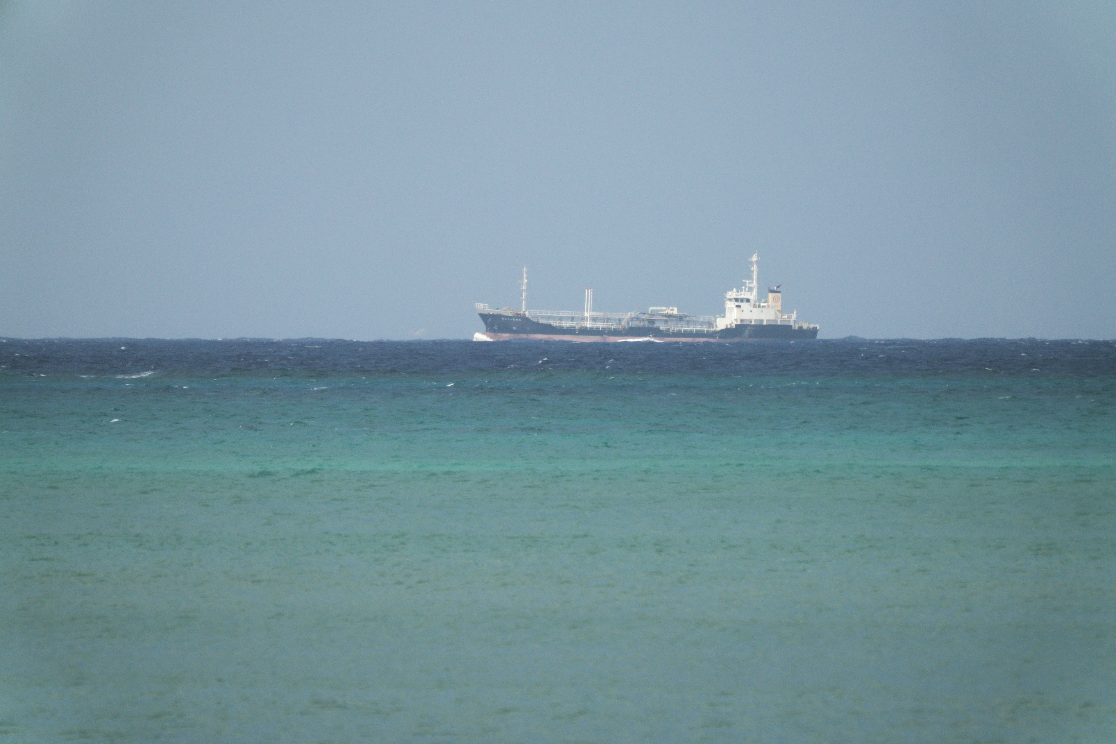 A ship floating on the blue sea with a calm backdrop