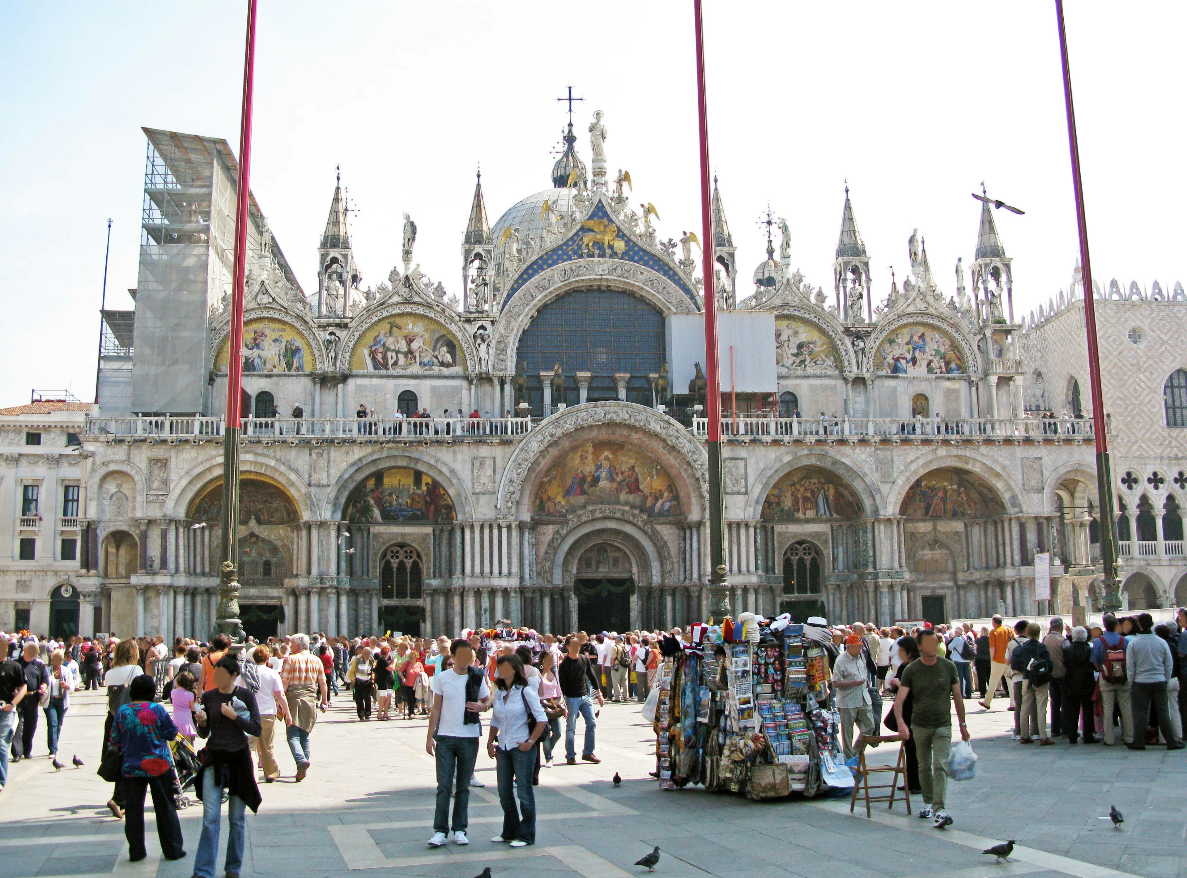 Tourists gathering in St Mark's Square with the grand facade of St Mark's Basilica