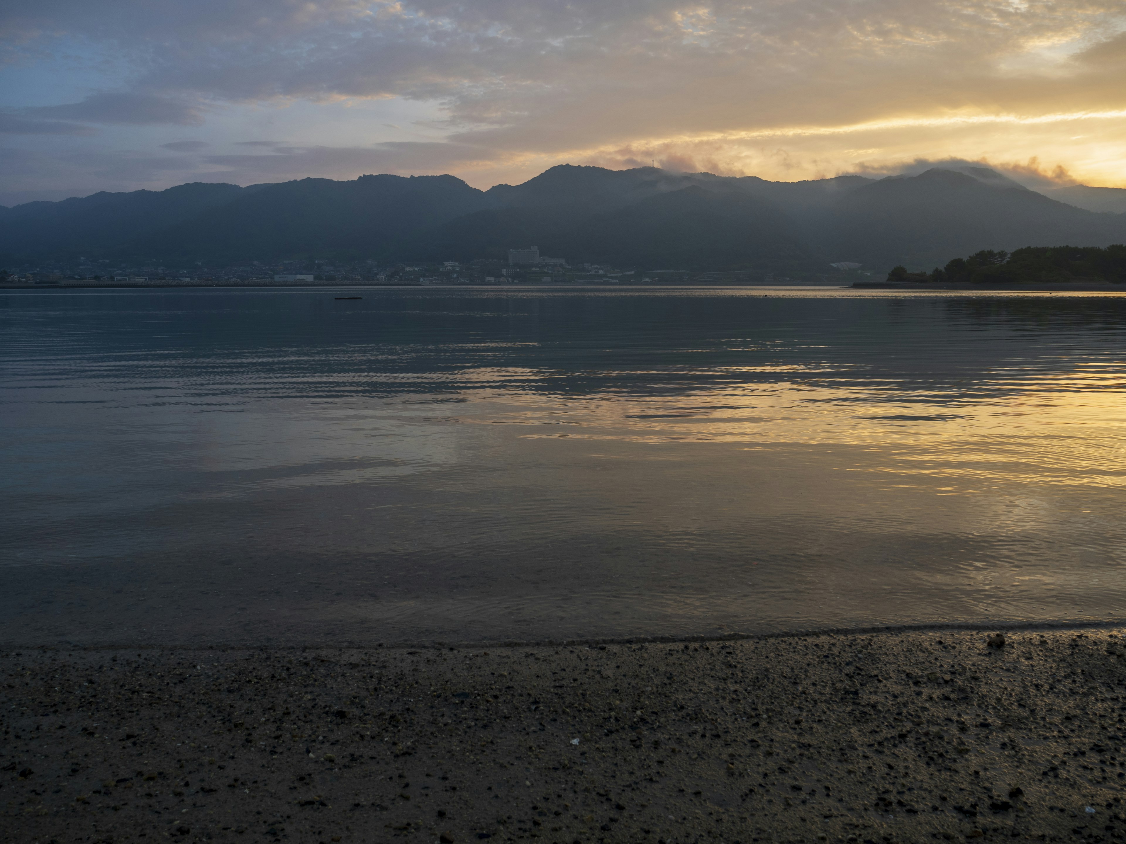 静かな湖面に映る山々の夕焼けの景色