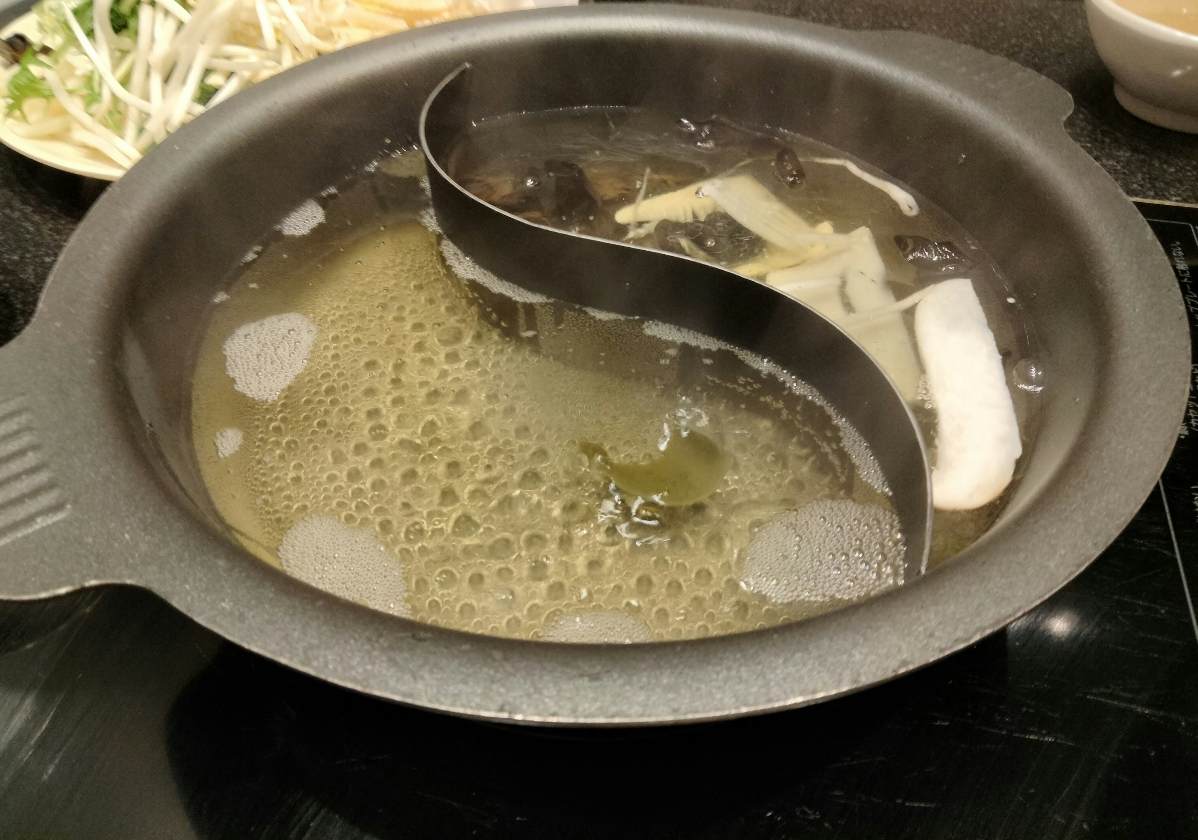 Hot pot with dual broth and various ingredients